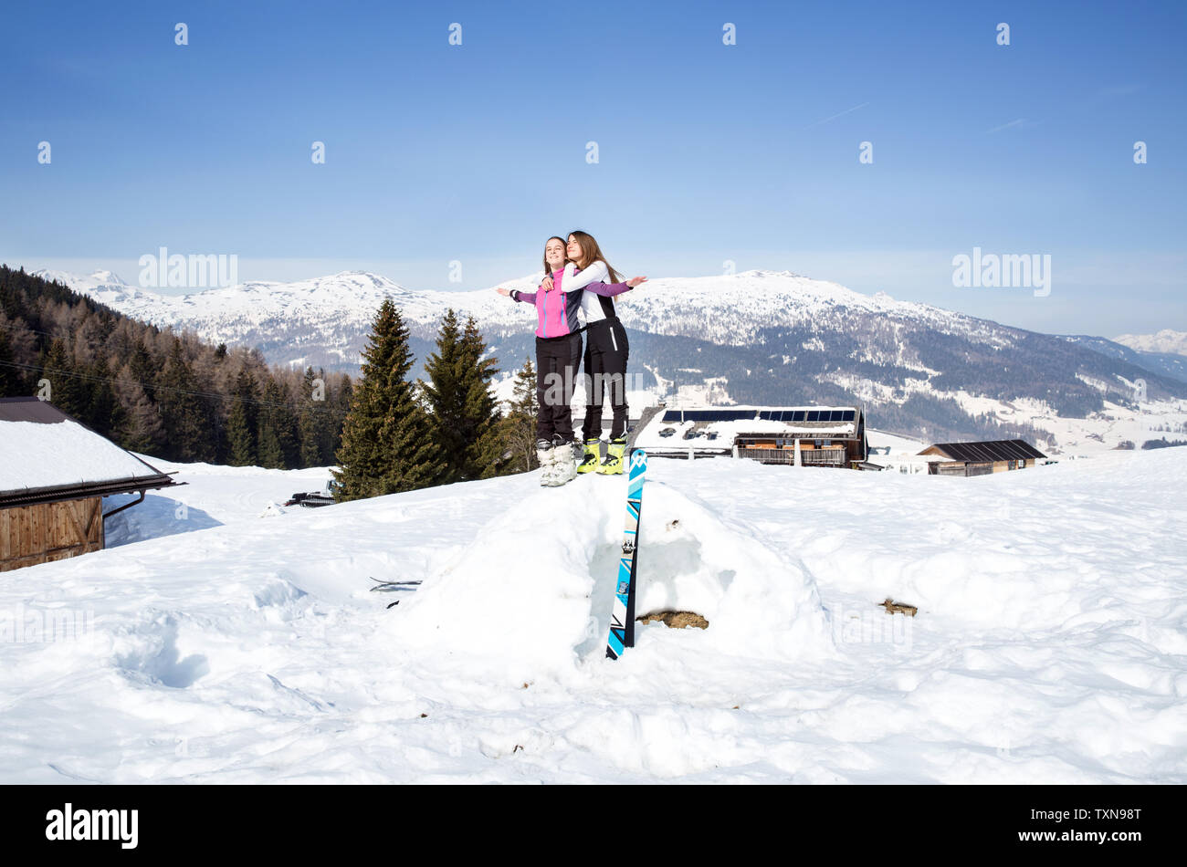 Due ragazza adolescente gli sciatori in piedi sulla sommità del tumulo di neve in paesaggi innevati, Tirolo, Stiria, Austria Foto Stock