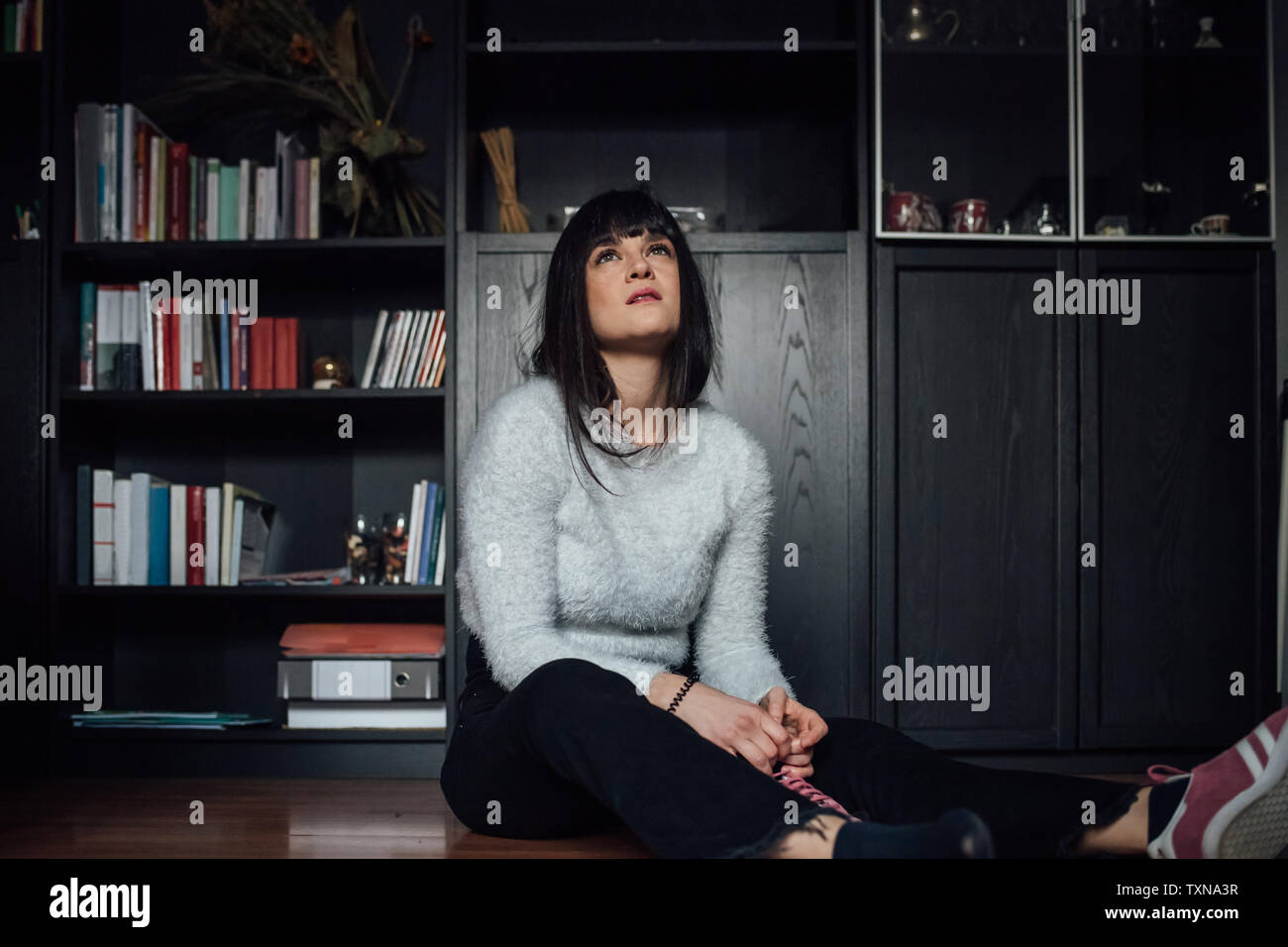 La donna nel pensiero profondo sul pavimento Foto Stock