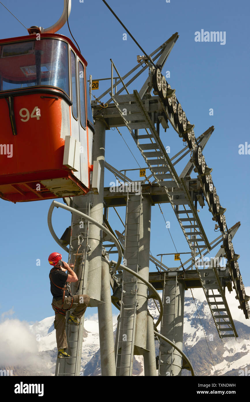 Lavoratore di manutenzione salendo funivia, Saas fee, Vallese, Svizzera Foto Stock