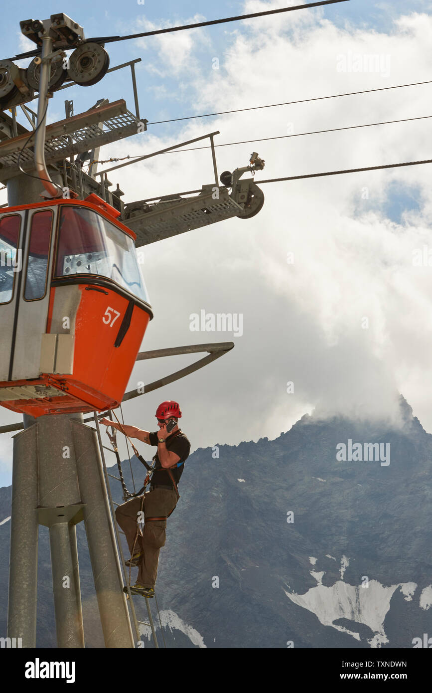 Lavoratore di manutenzione salendo funivia, Saas fee, Vallese, Svizzera Foto Stock
