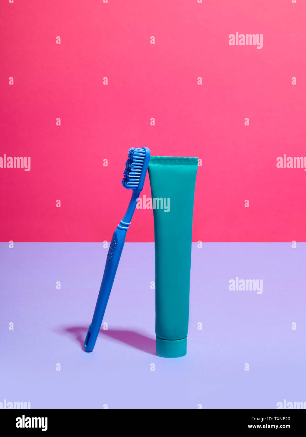 Spazzolino da denti e dentifricio contro rosa lilla e sfondo Foto Stock