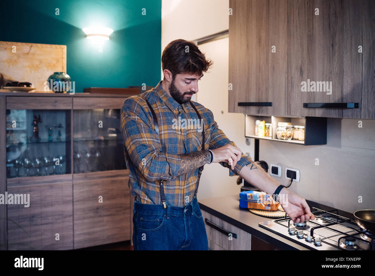 Metà uomo adulto in cucina di arrotolamento della manica Foto Stock
