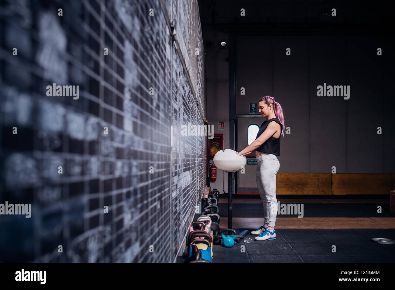 Giovane donna la polverizzazione di palme in palestra Foto Stock