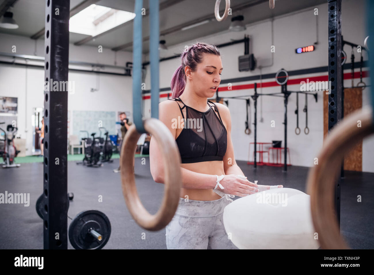 Giovane donna la polverizzazione di palme in palestra Foto Stock