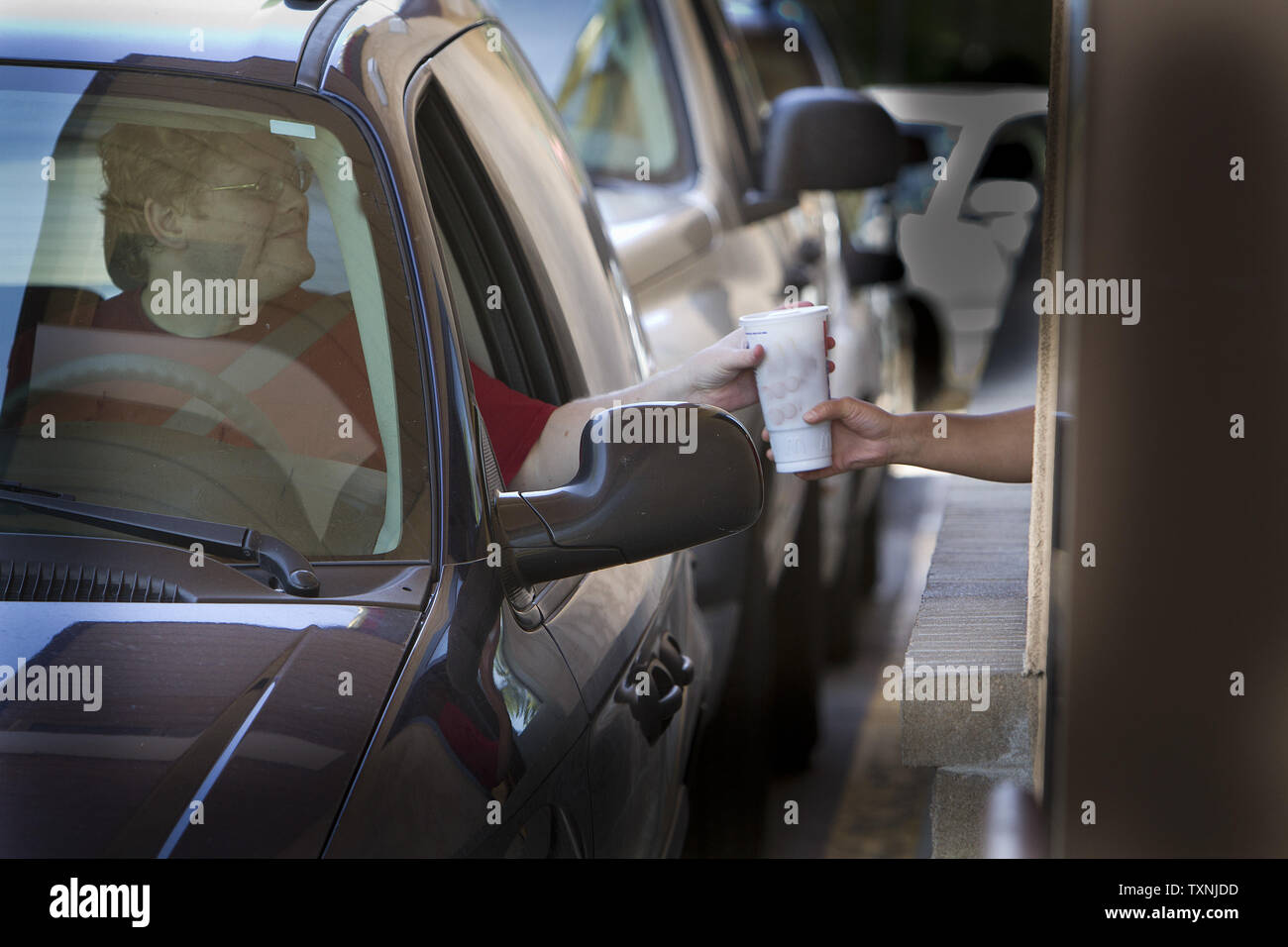 Un drive through ristorante patrono raggiunge per un soft drink durante le ore del pranzo a Denver il 31 maggio 2012. New York City mayor Michael Bloomberg sta proponendo di vietare qualsiasi bevande zuccherate maggiore di 16 once da ristoranti, teatri e cinema, carrelli di cibo e concessione sorge in uno sforzo per combattere l'obesità UPI/Gary Caskey C. Foto Stock