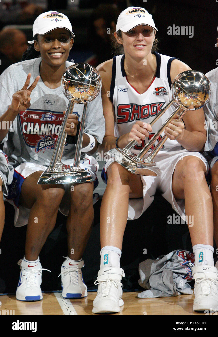 Shock di Detroit's Swin Cash, sinistra e Ruth Riley tenere la squadra di due WNBA Finals trofei dopo aver sconfitto i monarchi di Sacramento nel gioco cinque alla Joe Louis Arena di Detroit, Michigan il 9 settembre 2006. Lo Shock ha vinto il loro primo campionato nel 2003. (UPI foto/Scott R. Galvin) Foto Stock