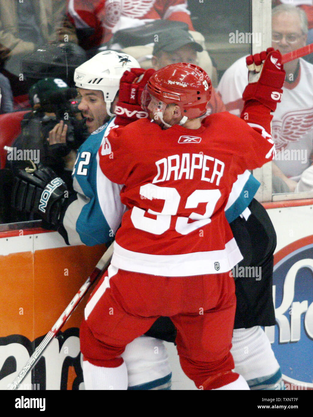 Ali rosse di Detroit center Kris Draper (33) controlli San Jose Sharks defenceman Scott Hannan (22) nei pannelli nel secondo periodo durante il gioco uno dei Western Conference semifinali a Joe Louis Arena di Detroit il 26 aprile 2007. (UPI foto/Scott R. Galvin) Foto Stock