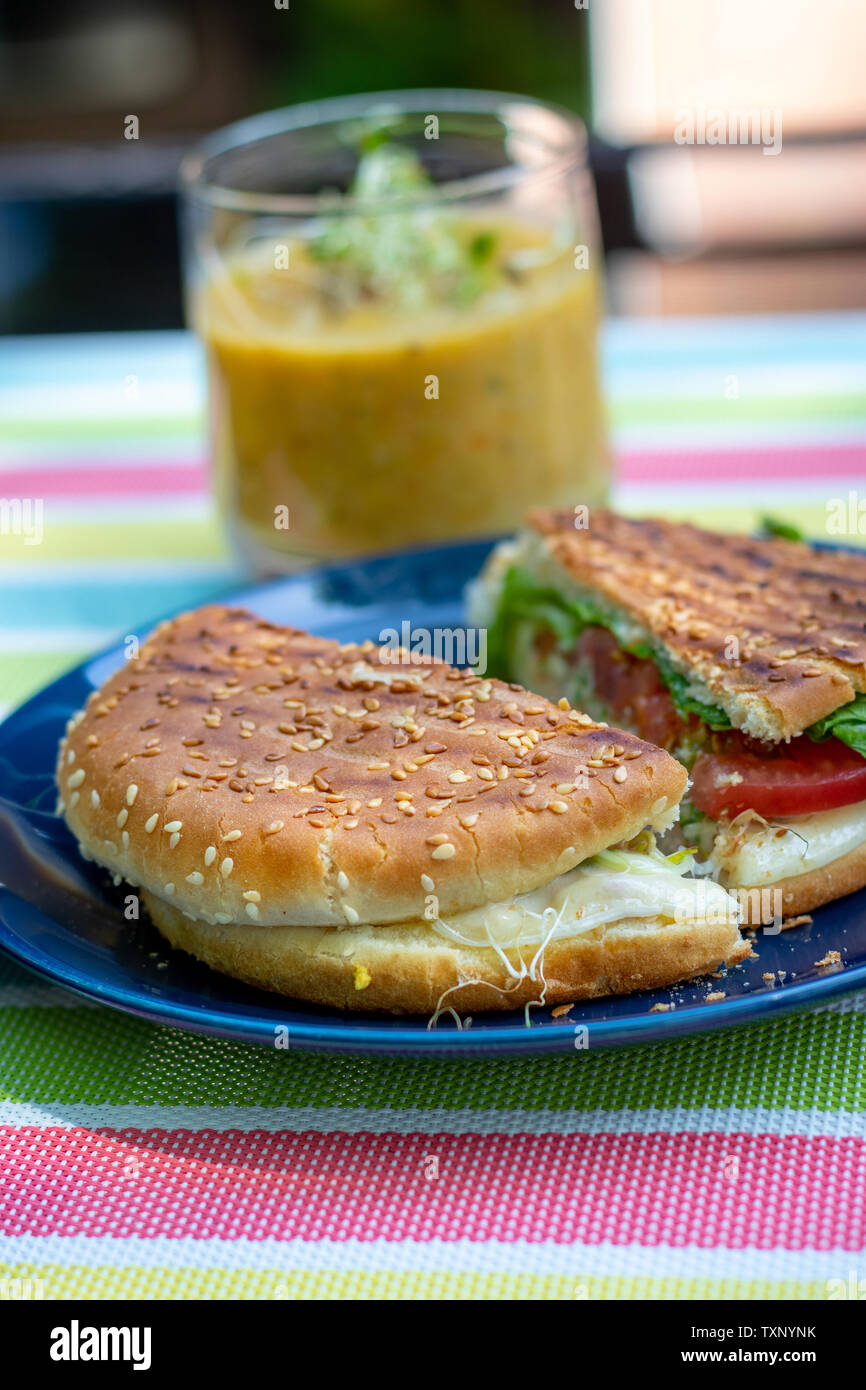Sandwich alla griglia snack con zuppa su un tavolo da terrazza in estate giornata di sole Foto Stock
