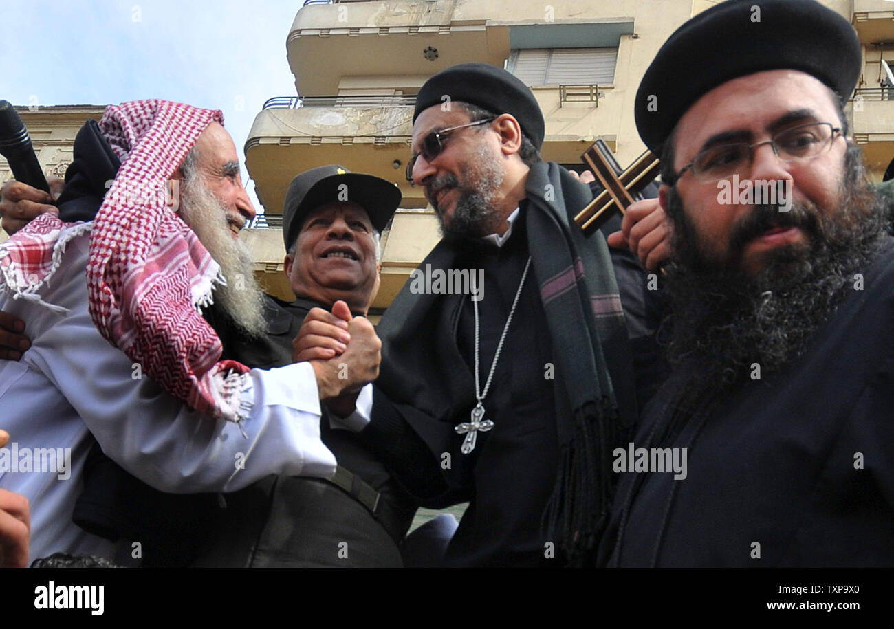 Un chierico cristiana stringe le mani con un musulmano sheik durante un rally per dimostrare l unità fra i musulmani e i cristiani a Piazza Tahrir al Cairo il 11 marzo, 2011. Il rally si svolge dopo i recenti scontri che hanno ucciso tredici persone. UPI/Mohammed Hosam Foto Stock