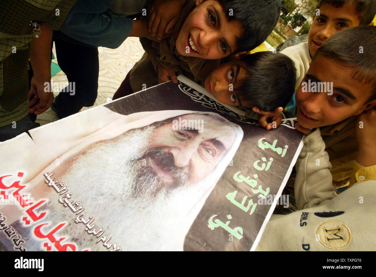 Un bambini palestinesi tenere poster ex Hamas Skekh Ahmad Easen, durante una manifestazione contro la politica israeliana verso bambini palestinesi e supporto F leader palestinese Yasser Arafat a Gaza City, 01 maggio 2004.(UPI foto/Ismael Mohamad) Foto Stock