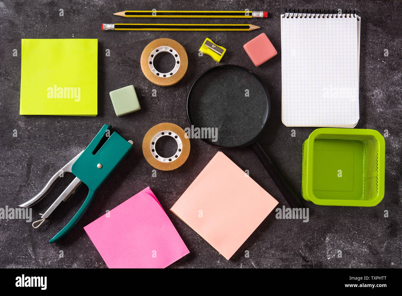 Assortita di forniture scolastiche su nero ardesia. Si torna a scuola concetto. Foto Stock