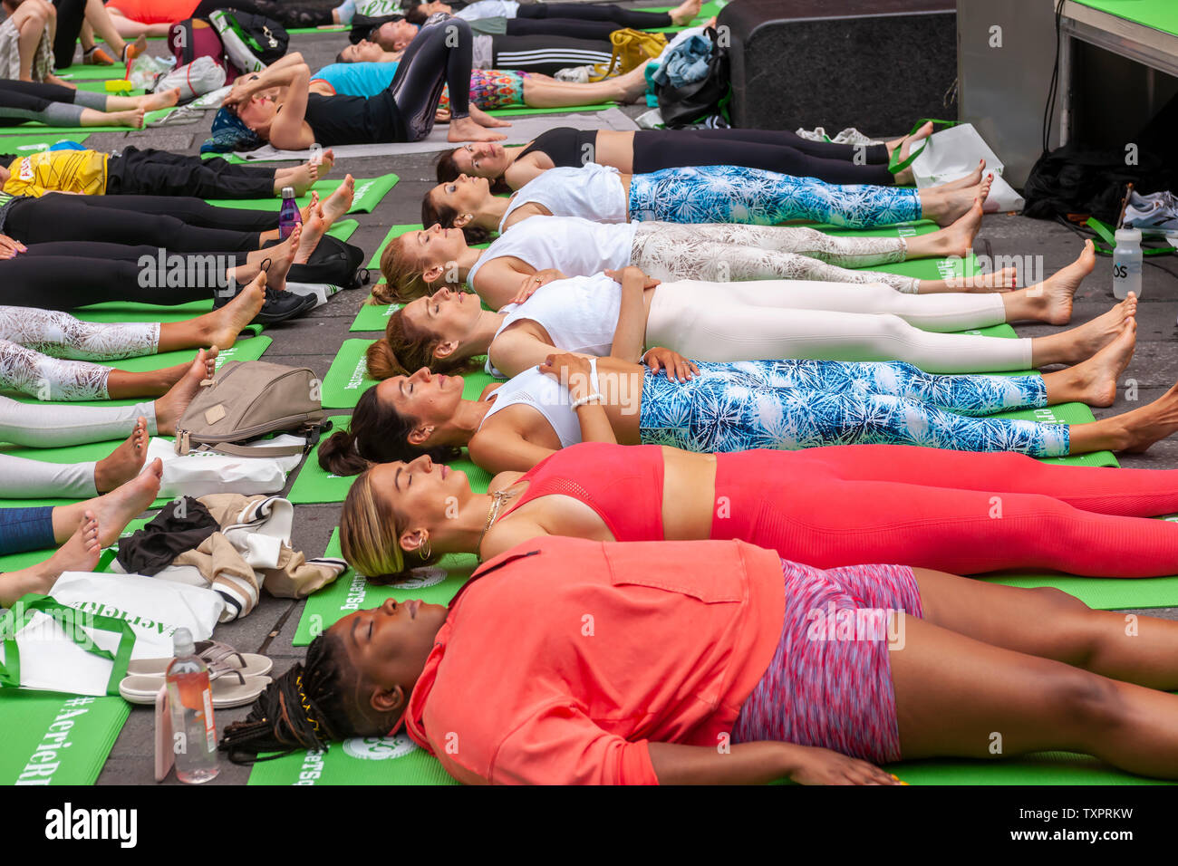 Migliaia di praticanti di yoga pack Times Square a New York per praticare lo yoga il primo giorno di estate, Venerdì 21 Giugno, 2019. Xvii annuale di Solstice in Times Square, 'Mind oltre follia", sponsorizzato da American Eagle Outfitters' marchio athleisure Aerie si estende il yogi' capacità di bloccare il rumore e il disordine visivo che li circondano nel crocevia del mondo. Il primo giorno di estate è stata dichiarata la Giornata Internazionale di Yoga dalle Nazioni Unite. (© Richard B. Levine) Foto Stock