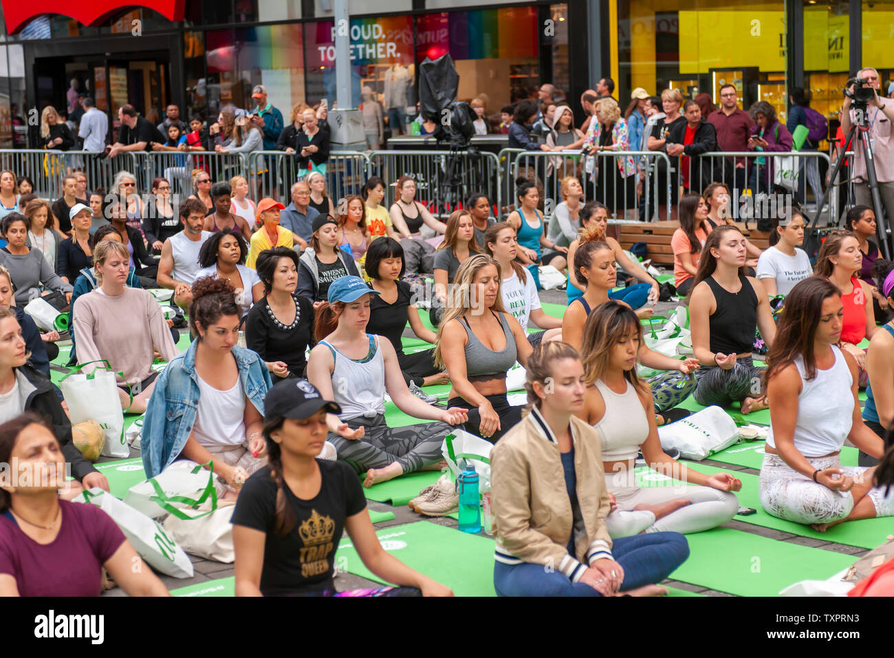 Migliaia di praticanti di yoga pack Times Square a New York per praticare lo yoga il primo giorno di estate, Venerdì 21 Giugno, 2019. Xvii annuale di Solstice in Times Square, 'Mind oltre follia", sponsorizzato da American Eagle Outfitters' marchio athleisure Aerie si estende il yogi' capacità di bloccare il rumore e il disordine visivo che li circondano nel crocevia del mondo. Il primo giorno di estate è stata dichiarata la Giornata Internazionale di Yoga dalle Nazioni Unite. (© Richard B. Levine) Foto Stock