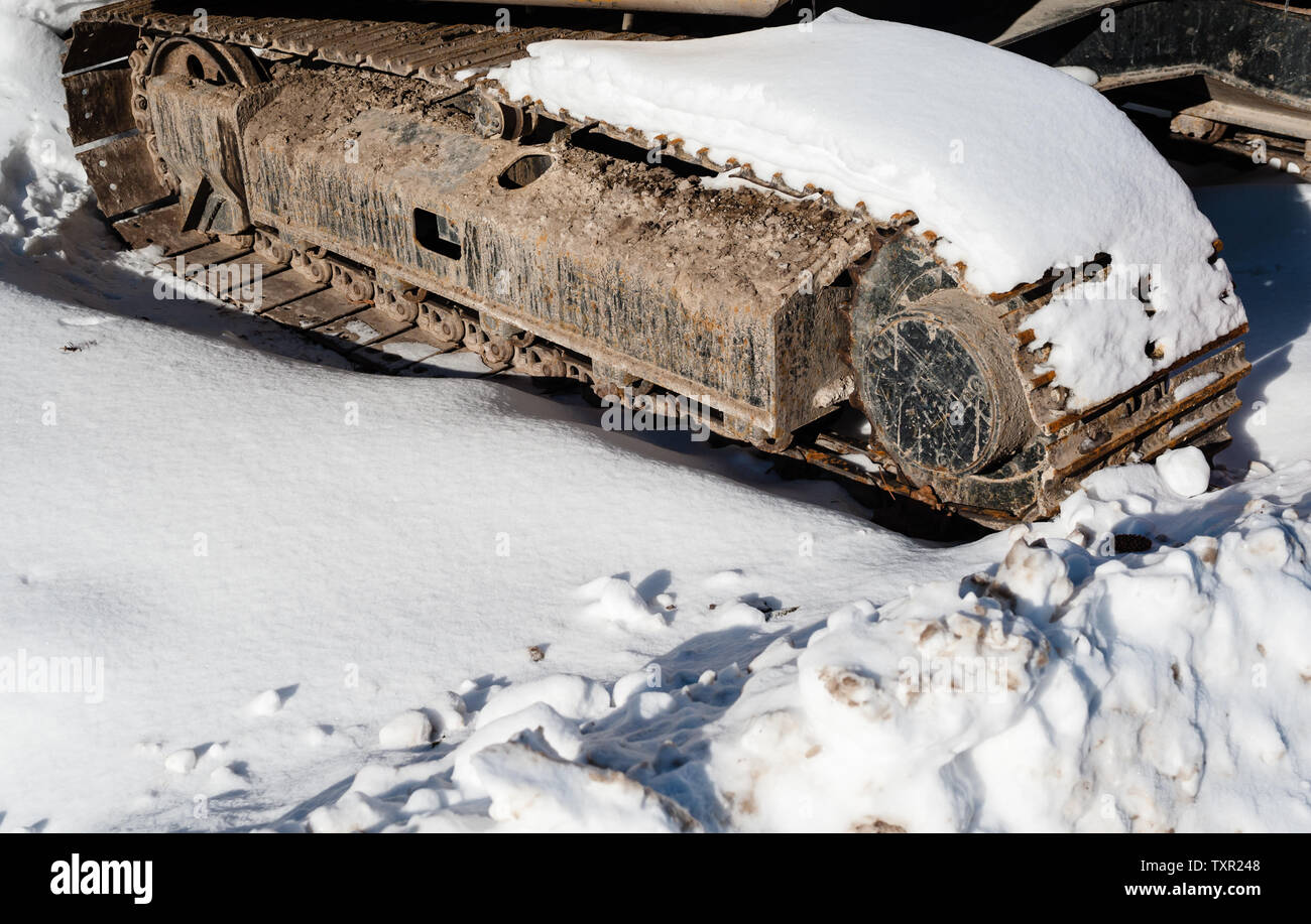 Parte di industriali pesanti tracce continue coperto di neve sulla giornata di sole. Foto Stock