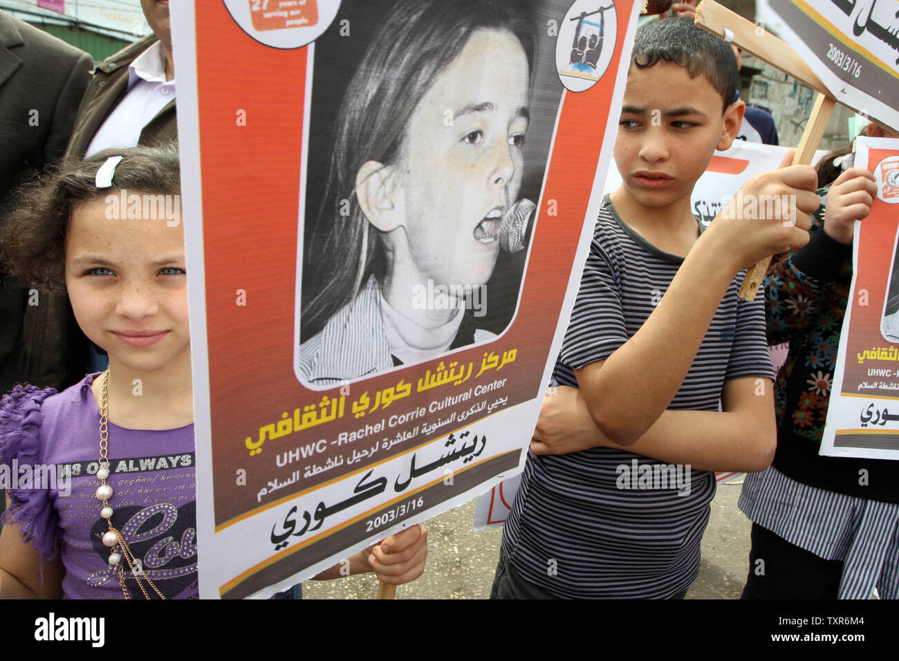 Ragazzi palestinesi detiene il poster di noi attivista di pace Rachel Corrie, che è stato ucciso da un esercito israeliano bulldozer nel 2003, durante una manifestazione di protesta dell'anniversario della sua morte in un campo di rifugiati a Rafah nella striscia di Gaza meridionale, il 16 marzo 2013. Corrie, 23, è stato ucciso da un esercito di bulldozer a Rafah nel marzo 2003 come lei e altri attivisti hanno cercato di impedire che le truppe la demolizione di una casa. UPI/Ismael Mohamad.. Foto Stock