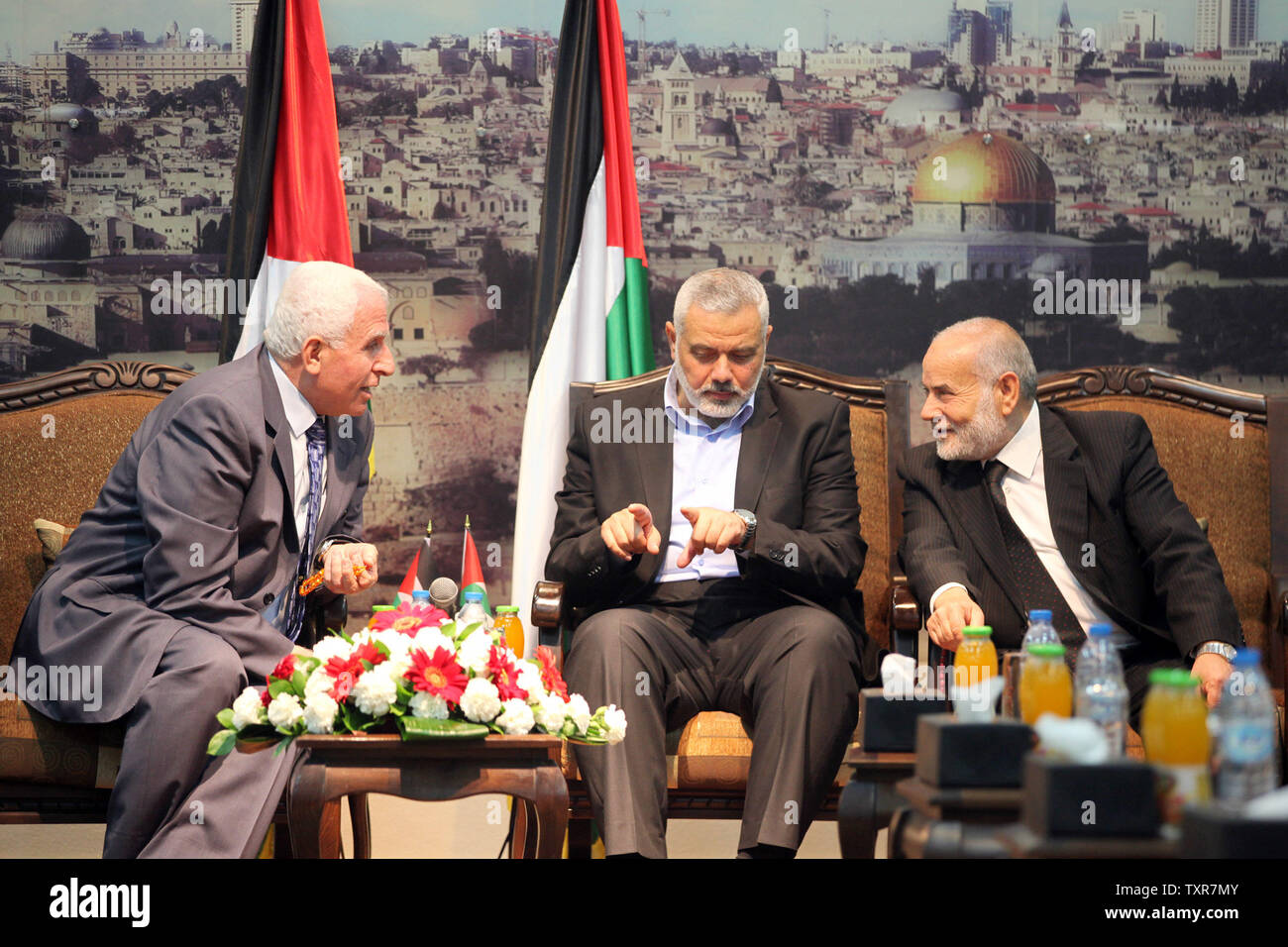 A capo della delegazione dell'Organizzazione per la liberazione della Palestina (OLP)e senior figura nel mainstream Fatah partito del presidente Mahmud Abbas Azzam al-Ahmad (2L), Hamas il primo ministro nella Striscia di Gaza Ismail Haniya (2R), e vice capo del parlamento palestinese Ahmad Bahar (R) chat durante un incontro con i membri della delegazione OLP e leader delle fazioni palestinesi nella sua casa nella città di Gaza il 22 aprile 2014. I palestinesi hanno rilanciato gli sforzi per conciliare la loro leadership rivale in Cisgiordania e nella Striscia di Gaza come US-mediate i colloqui di pace con Israele teeter sul bordo della colla Foto Stock