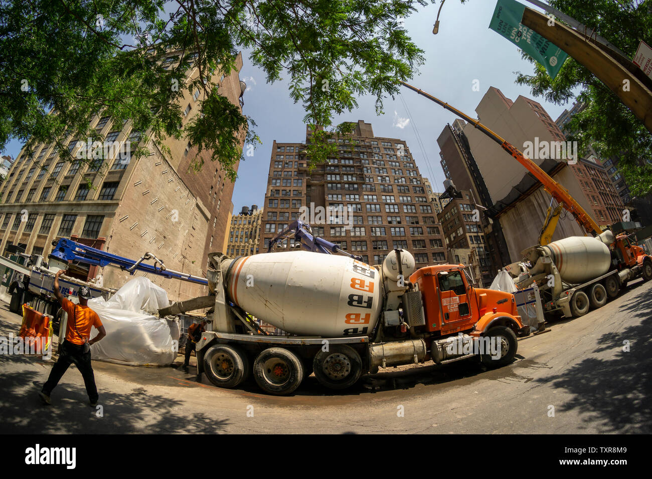 Una carovana di camion di cemento consegnare a un sito in costruzione nella New York quartiere di Chelsea Sabato, 22 giugno 2019. Secondo un recente studio di circa il 40 percento di appartamenti e case in vendita o in affitto sono all'interno di due blocchi di un sito in costruzione. (© Richard B. Levine) Foto Stock