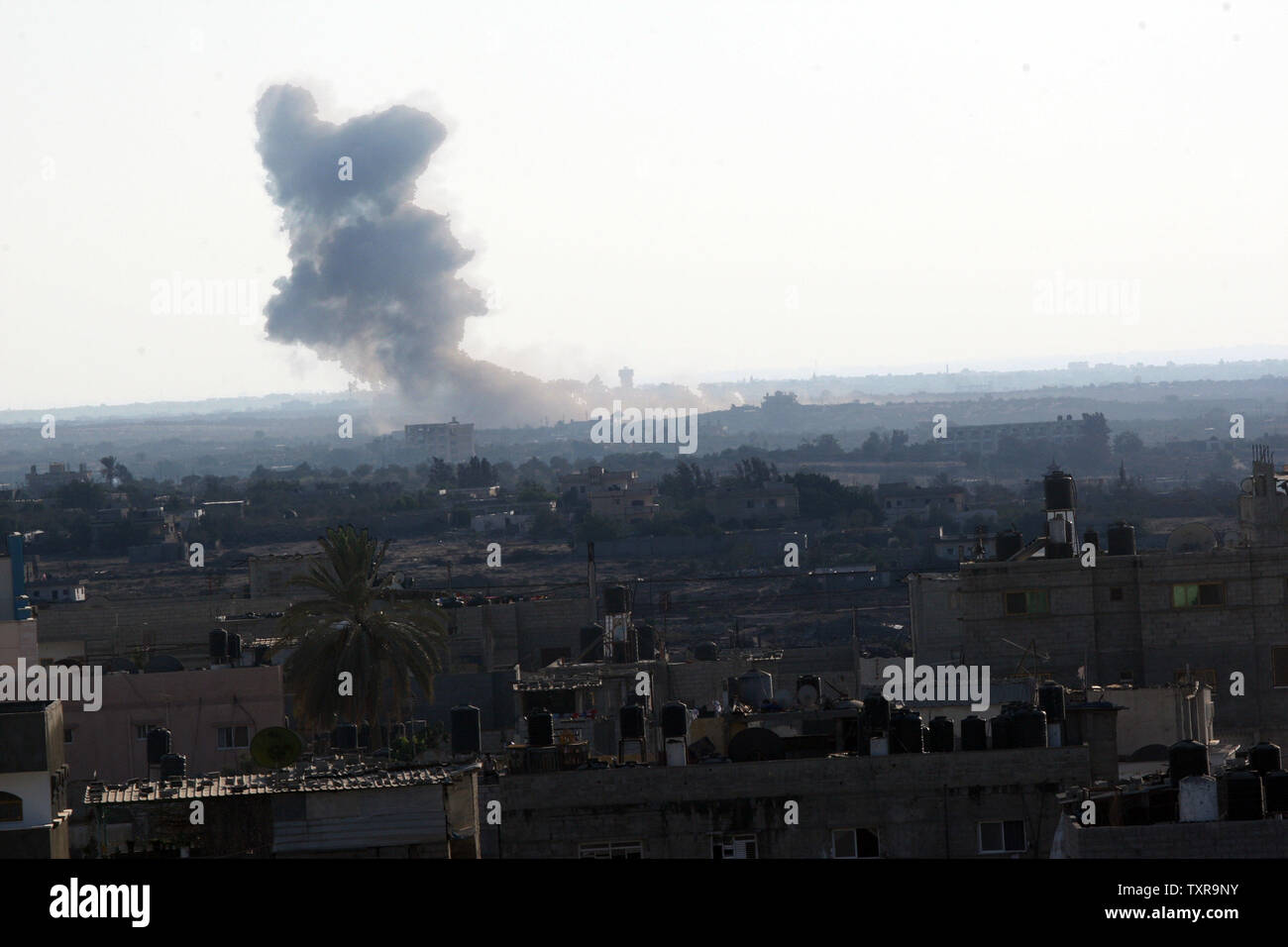 Una foto scattata da Rafah confine del sud della striscia di Gaza con l'Egitto il 17 settembre 2015 mostra fumo dopo un Egiziano aerei sciopero in Egitto il Sinai settentrionale, dove l'esercito Egiziano è costantemente in lotta contro i militanti. Il 15 settembre, otto turisti messicano morì dopo egiziano le forze di sicurezza hanno attaccato erroneamente un safari nel deserto. Foto di Ismael Mohamad/UPI Foto Stock