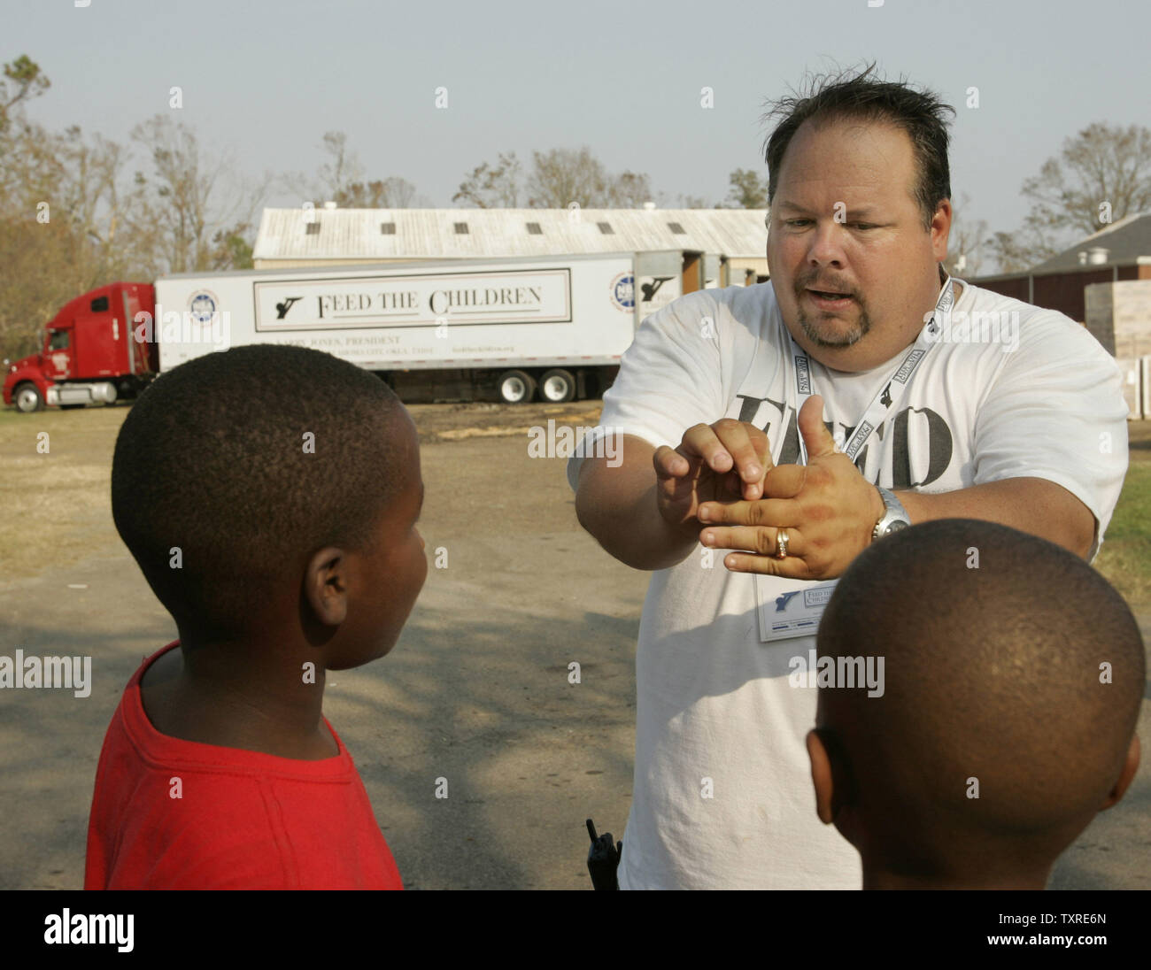 Alimentare i bambini sponsor Rickett Jack di Elizabethtown, KY, ospita una coppia di bambini in attesa di NBA i giocatori di basket di arrivare per iniziare a dare il cibo, articoli da toeletta e forniture scolastiche a seguito dell'Uragano Katrina alla prima assemblea di Dio chiesa di Gulfport, MS, sul Sett. 15, 2005. Rickett del gruppo di 31 persone da Coral Hill chiesa battista a Glasgow, KY, portata 23 camion di forniture di uragano-devastata costa del Golfo. (UPI foto/Billy Suratt) Foto Stock