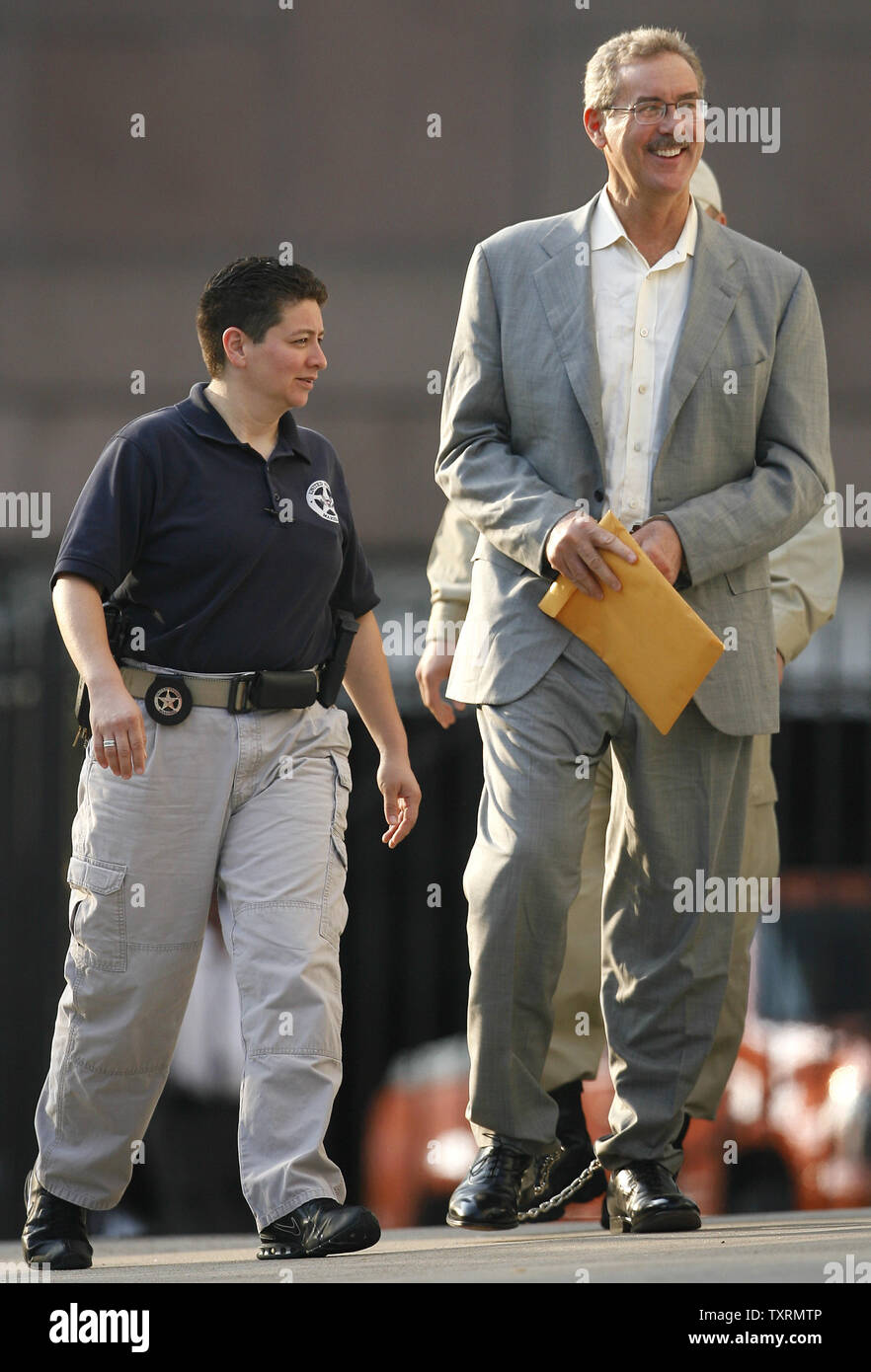 Finanziere R. Allen Stanford (R) è scortato in Federal Courthouse in manette per un' audizione su se un ordine concessione lui bail dovrebbe essere invertita a Houston, in Texas, il 29 giugno 2009. Stanford è stato incriminato da un gran giurì federale insieme ad altre cinque persone tra cui un ex regolatore Antiguan su oneri hanno diretto a 7 miliardi di dollari di frode per la vendita di certificati di deposito attraverso la sua banca Antiguan. (UPI foto/Aaron M. Sprecher) Foto Stock