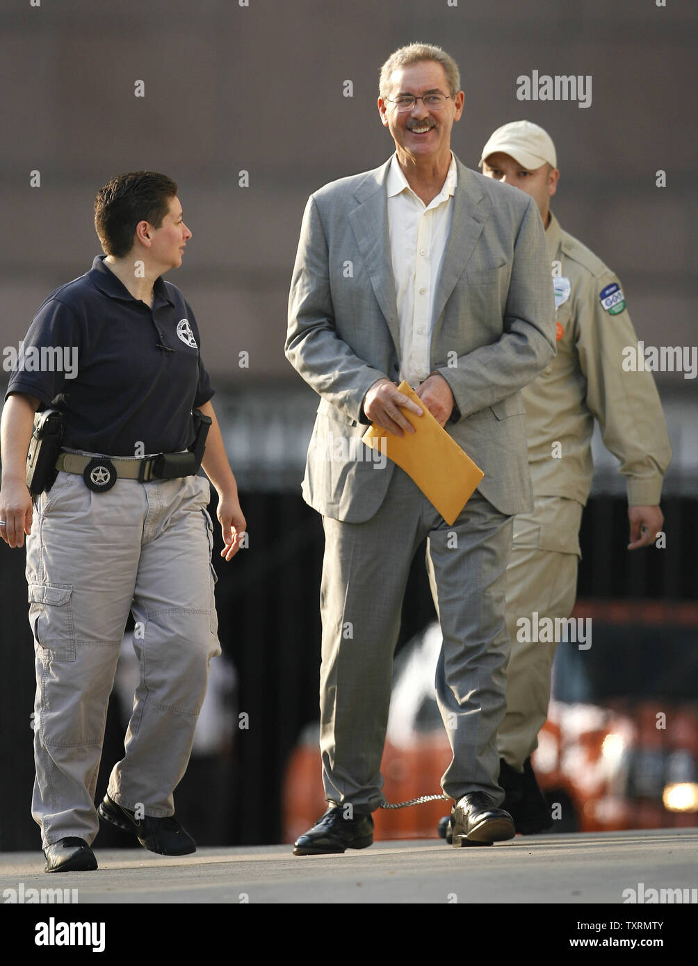 Finanziere R. Allen Stanford (C) è scortato in Federal Courthouse in manette per un' audizione su se un ordine concessione lui bail dovrebbe essere invertita a Houston, in Texas, il 29 giugno 2009. Stanford è stato incriminato da un gran giurì federale insieme ad altre cinque persone tra cui un ex regolatore Antiguan su oneri hanno diretto a 7 miliardi di dollari di frode per la vendita di certificati di deposito attraverso la sua banca Antiguan. (UPI foto/Aaron M. Sprecher) Foto Stock