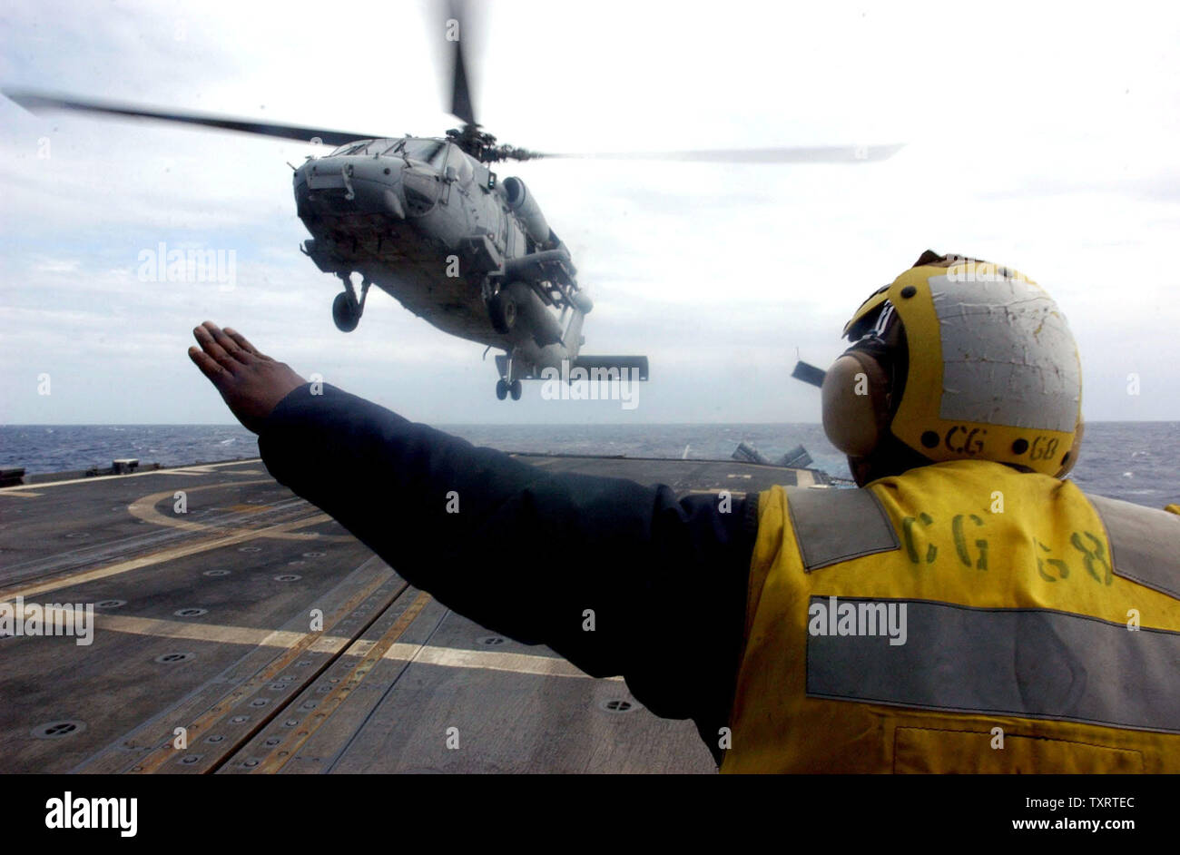 HST2003031902 - a bordo della USS ANZIO, Mediterraneo orientale, 19 marzo (UPI) -- Un crewman a bordo dell'incrociatore USS Anzio dirige un SH-60 Seahawk elicottero dalla portaerei USS Harry Truman in per un atterraggio nel Mediterraneo orientale su Mercoledì, 19 marzo 2003. jg/John Gillis UPI Foto Stock