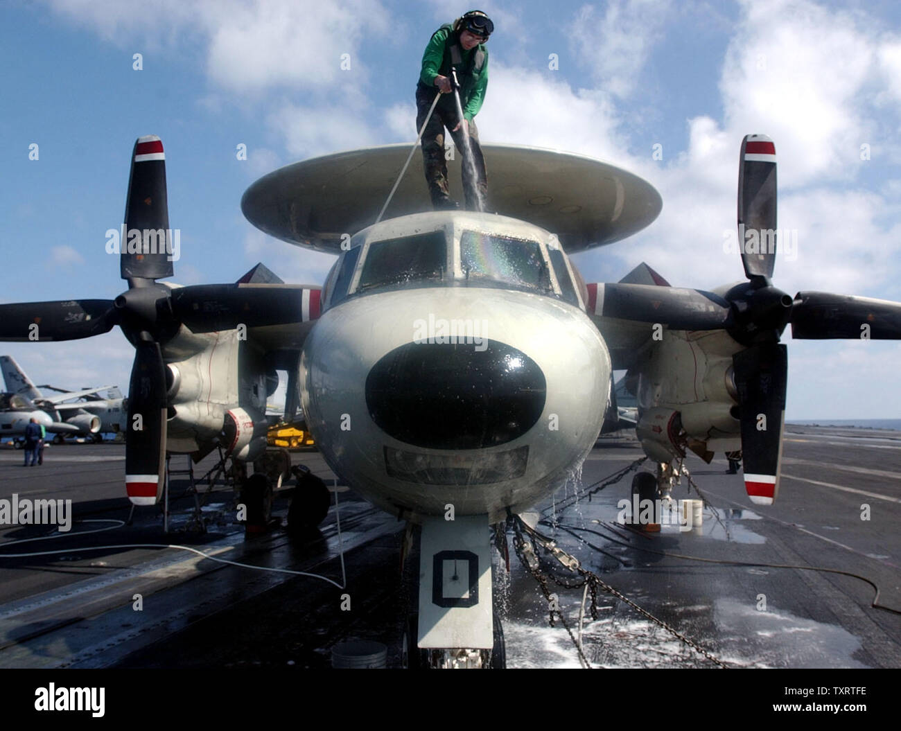 HST2003031605 - a bordo della USS Harry Truman, Mediterraneo orientale, Marzo 16 (UPI) - AMAN Donald Boylen di Chalseton, W. Va., tubi flessibili verso il basso una E-2C Hawkeye sul ponte di volo della USS Harry Truman, 16 marzo 2003 nel Mediterraneo orientale. jg/John Gillis UPI Foto Stock