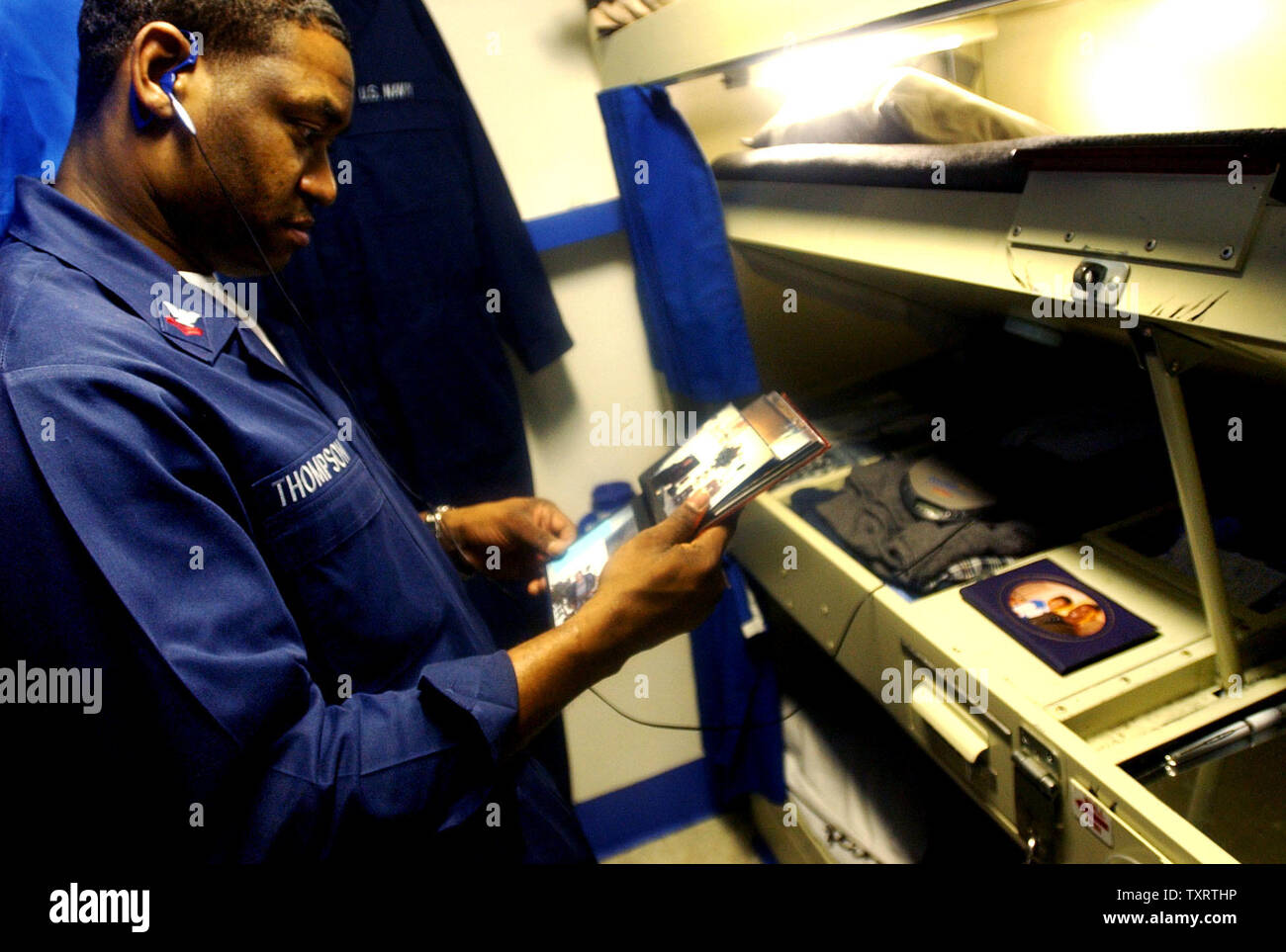 HST2003033001- USS Harry Truman, Mediterraneo orientale, 30 marzo (UPI)-- SN Trevor Baker di Landover, Md., guarda le foto della sua famiglia nel suo approdo a bordo della portaerei USS Harry Truman su Marzo 30, 2003 nel Mediterraneo orientale Mare. nn/jg/John Gillis UPI Foto Stock