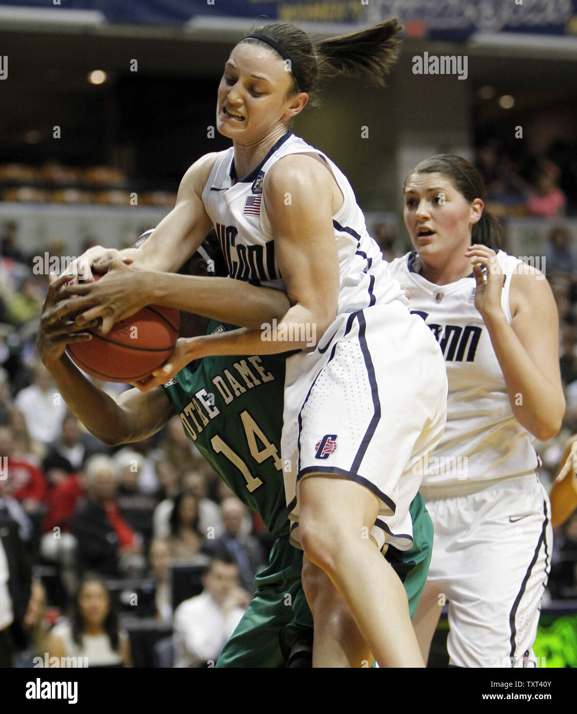 Notre Dame Fighting Irish guard Devereaux Peters (14) battaglie Connecticut Huskies difensori Bria Hartley, centrale e Stefanie Dolson, a destra per una sfera allentato nella prima metà di loro NCAA finale donne quattro game al Conseco Fieldhouse di Indianapolis il 3 aprile 2011. UPI /Mark Cowan Foto Stock