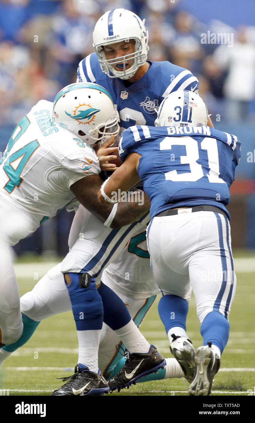 Indianapolis Colts quarterback Andrea Fortuna è saccheggiato dai delfini di Miami Phillip Wheeler (retro) e Randy Starks (94) come Colts running back Donald marrone (31) tenta di blocco nel quarto trimestre a Lucas Campo dell'olio a Indianapolis, Indiana, il 15 settembre 2013. I Delfini sconfitti i Colts 24-20. UPI/Mark Cowan Foto Stock