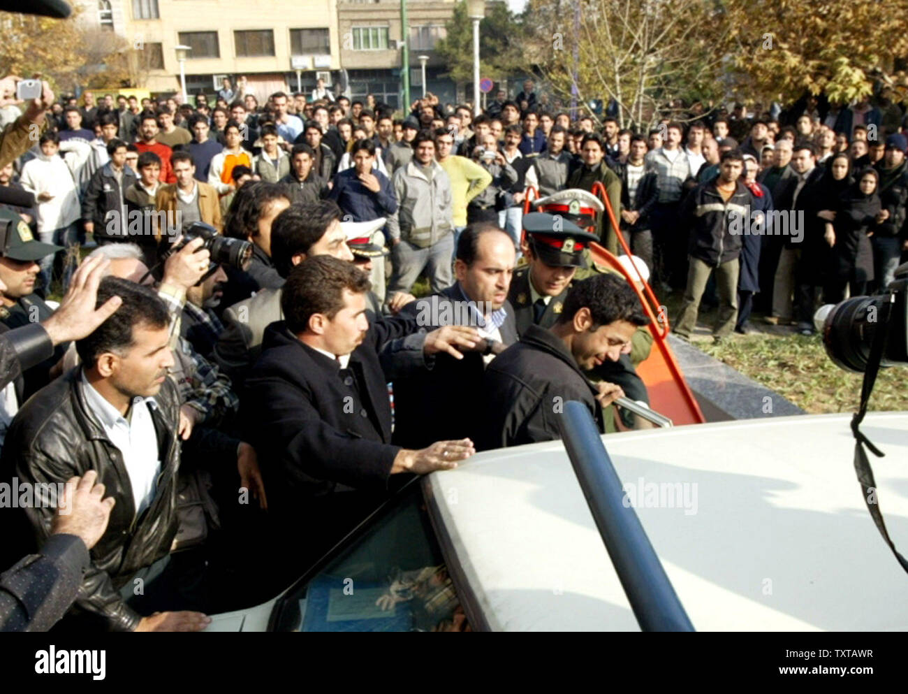 Il governo iraniano dal nome della SINA (C) è scortato dalla polizia dopo che appare il tentativo di suicidio in uptown strade di Teheran il 30 novembre 2005. (UPI foto/Mohammad Kheirkhah) Foto Stock