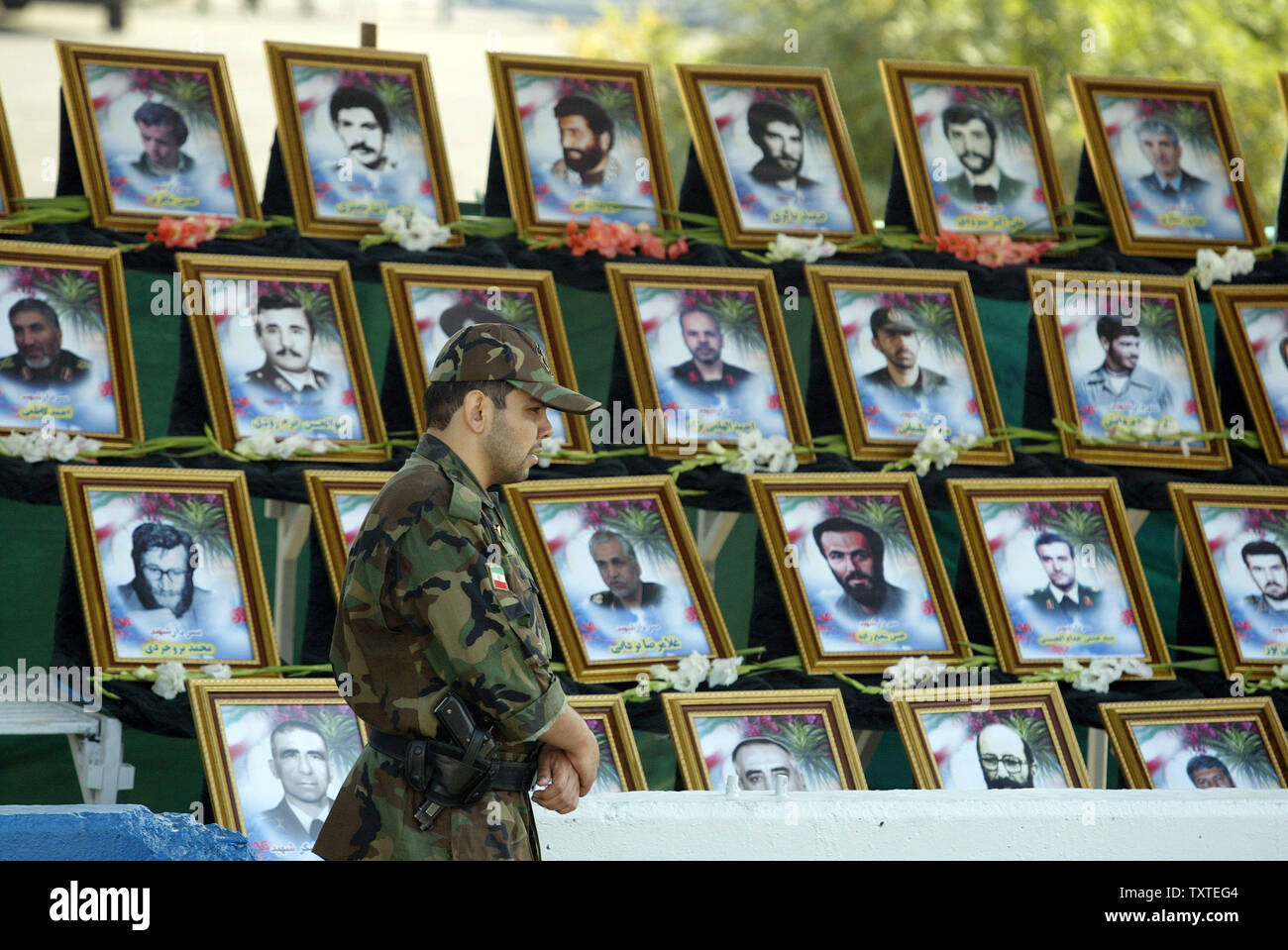 Un esercito iraniano soldato sta di guardia di fronte a foto dei comandanti iraniani che erano stati uccisi nella guerra Iran-Iraq (1980-88) durante una parata che segna il 27° anniversario dell'inizio della guerra Iran-Iraq (1980-1988) di fronte al mausoleo del tardo rivoluzionario fondatore Ayatollah Ruhollah Khomeini, appena fuori di Tehran, Iran il 22 settembre 2007. (UPI foto/Mohammad Kheirkhah) Foto Stock