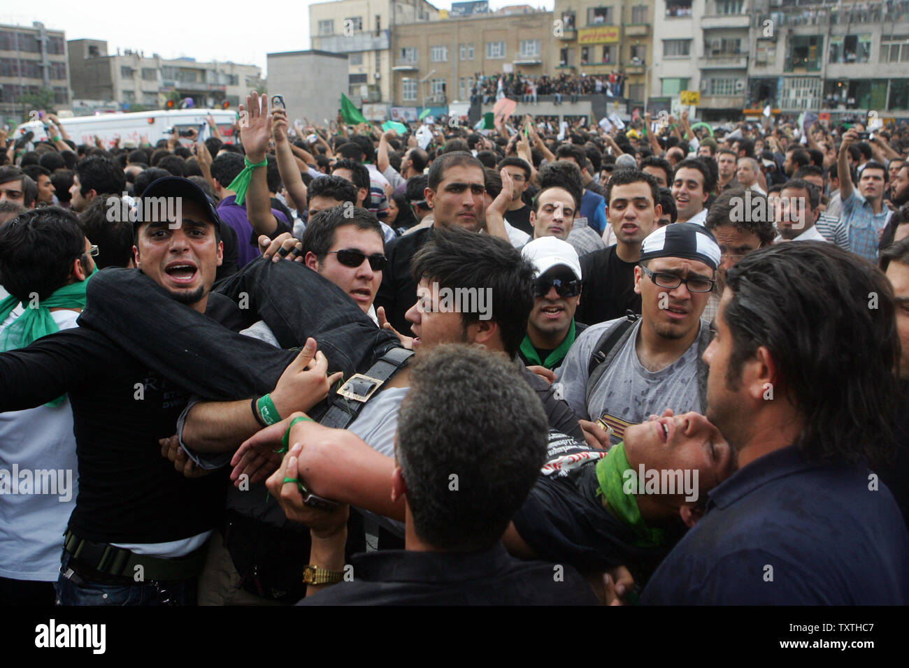 I sostenitori del candidato riformista Mir Hossein Mousavi portano un uomo ferito in strada a Tehran, Iran per dimostrare contro i risultati del Iraniano elezione presidenziale del 18 giugno 2009. UPI (foto) Foto Stock