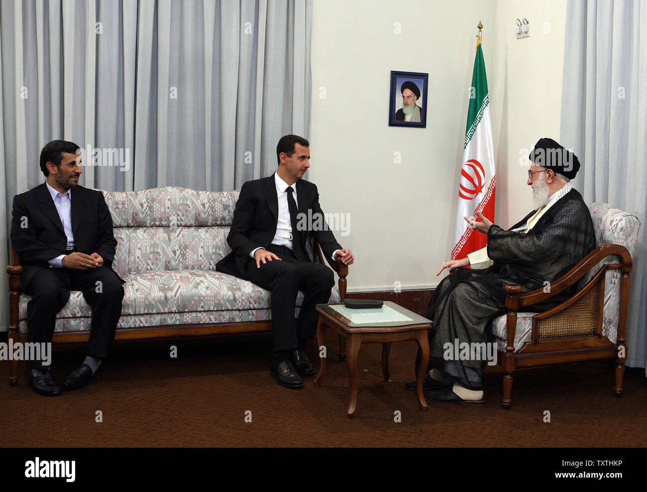 All'Iran il leader supremo Ayatollah Ali Khamenei (r) parlare con il Presidente siriano Bashar al-Assad (c) come il presidente iraniano Mahmoud Ahmadinejad li guarda il 19 agosto 2009 presso l ufficio leader in Tehran , Iran. Questo è Bashar al-AssadÕs quarta visita a Teheran poiché Ahmadinejad è diventato presidente nel 2005, Assad la visita segue la Siria il ruolo chiave nella liberazione di studente francese Clotilde Reiss e Nazak Afshar, un impiegato iraniano presso l' ambasciata di Francia. La donna francese incaricato di aiutare un complotto contro il governo iraniano durante l elezione e post-tempo di elezioni. All inizio di questa settimana la donna francese Foto Stock