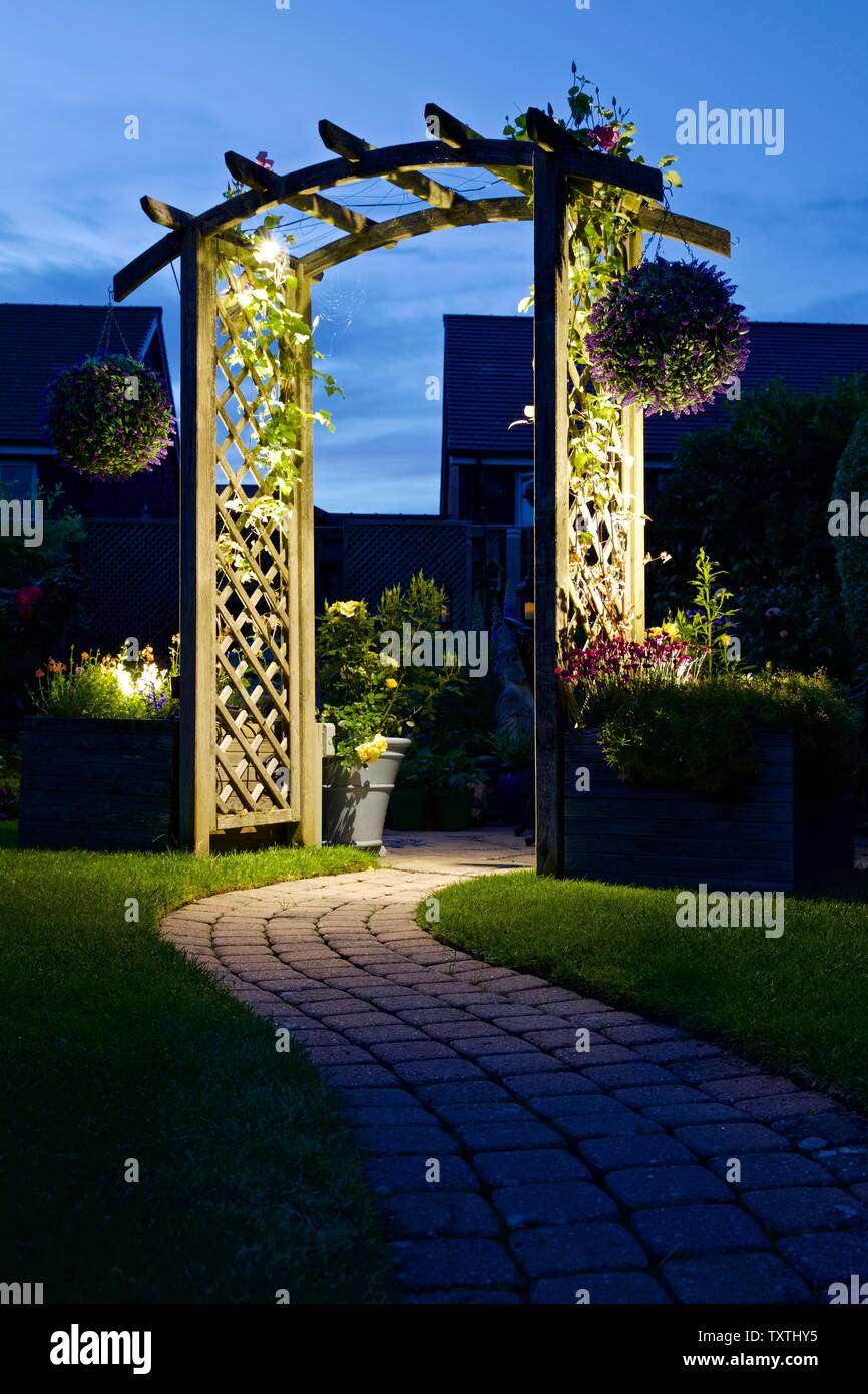 Luci esterne illuminare un giardino arch Foto Stock