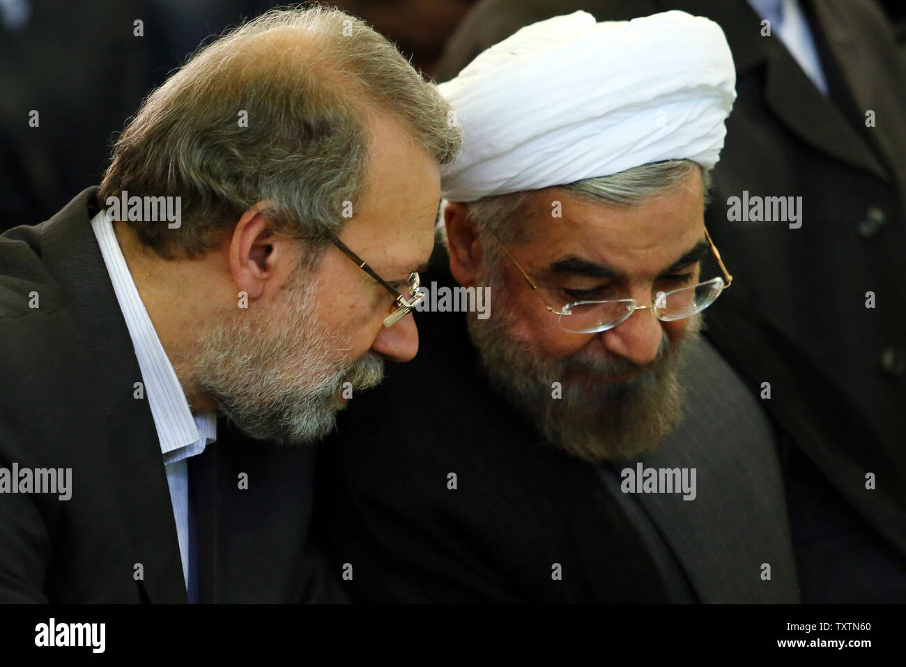 Questa foto ufficiale messo a disposizione da dell'Iran leader supremo sito web mostra dell'Iran speaker del parlamento Ali Larijani (L) parlando con l'Iran è di nuovo presidente Hassan Rouhani (R) durante l'Eid-al-Fitr preghiera a Tehran university di Tehran, Iran il 9 agosto 2013. L'Eid-al-Fitr festival segna la fine del santo Musulmano il mese di digiuno del Ramadan. UPI Foto Stock
