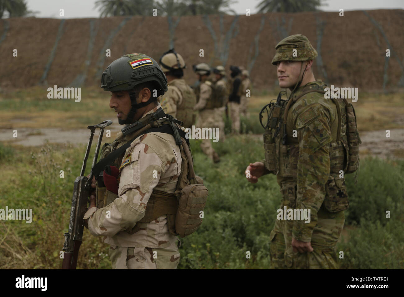 Un soldato Australiano, Assegnato a gruppo attività Taji, valuta soldati iracheni con 4° Battaglione, XXIII esercito iracheno brigata, sulla loro capacità di pattugliamento per una valutazione delle competenze presso il Camp Taji, Iraq, 28 marzo 2016. Gruppo di attività condotte Taji la valutazione delle competenze per valutare la competenza soldiersÕ nella base di combattere le attività. Attraverso la consulenza e assistenza e la costruzione di capacità del partner missioni, la Combined Joint Task Force C operazione inerente ResolveÕs coalizione multinazionale ha addestrato più di 19.9K personale per sconfiggere lo Stato islamico dell Iraq e il levante. Foto di Sgt. Paolo Vendita/STATI UNITI Esercito/UPI Foto Stock