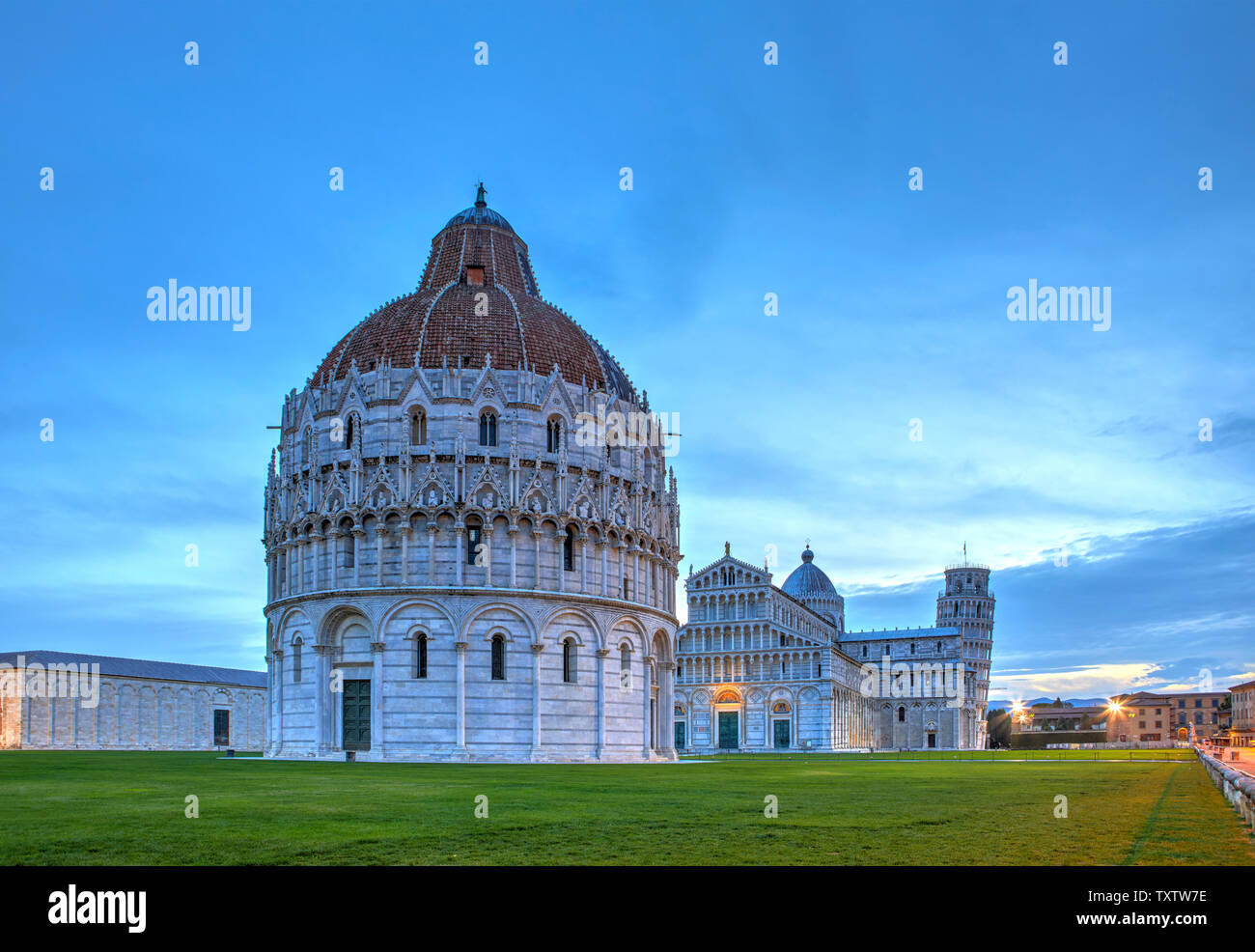 Il battistero in primo piano, il Duomo e la torre pendente in background, Pisa, Italia Foto Stock