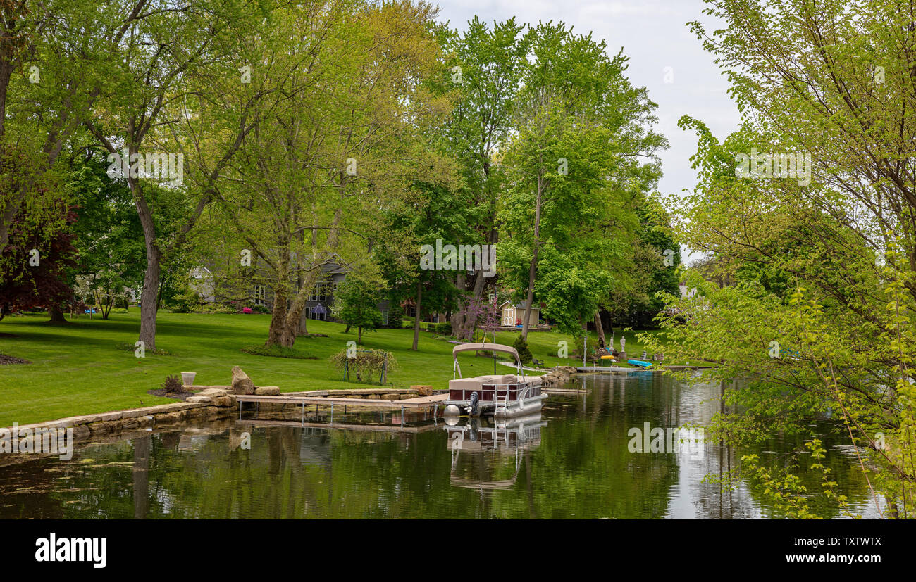 Il Cantone, Ohio lake, STATI UNITI D'AMERICA. Il 7 maggio 2019. Paesaggio sereno, una barca in acqua, erba verde e alberi, giornata di primavera Foto Stock