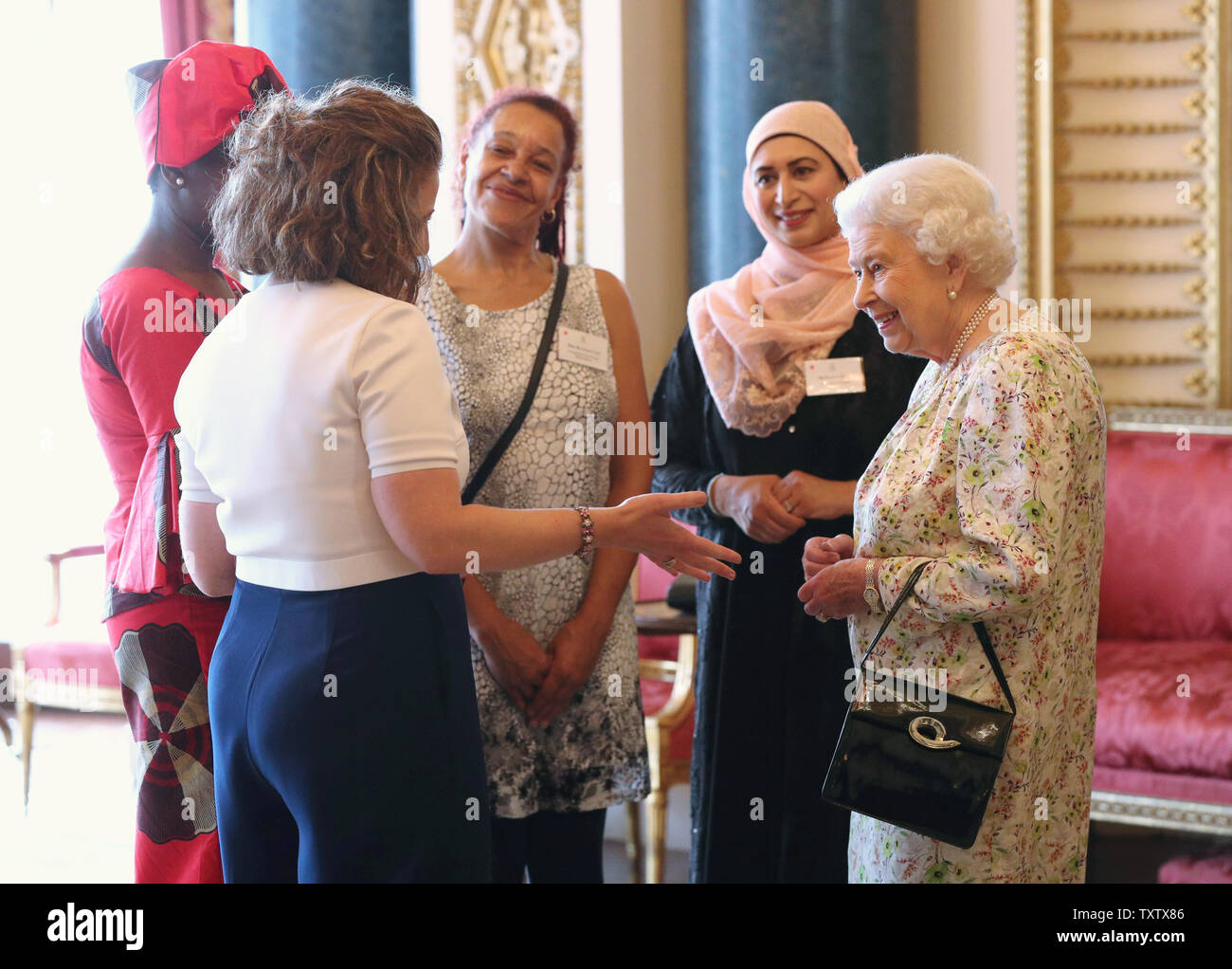 Queen Elizabeth II saluta (da sinistra a destra) Valentine Nkoyo, Anna Dyson, Rachael Cox e Nighat Khan durante un ricevimento a Buckingham Palace di Londra, per celebrare il lavoro del Regno Unito fede e credenza in gruppi portando le comunità locali insieme. Foto Stock