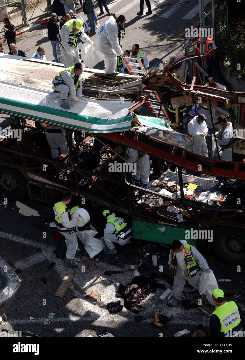 Ultra israeliano-ortodossi volontari clean up resti umani presso il sito di un bus bombardato da un attentatore suicida nel centro di Gerusalemme, vicino al Primo Ministro Ariel Sharon ha la residenza, uccidendo 10 e ferendone 45, 29 gennaio 2004. La micidiale bomba bus non si è fermata la controversa prigioniero scambia tra Israele e gli Hezbollah luogo oggi. (UPI foto/Debbie Hill) Foto Stock