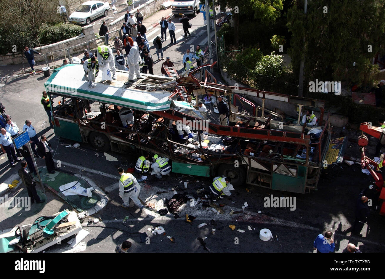 Israeliano esperti forensi e ultra-ortodossi volontari pick up resti umani presso il sito di un bus bombardato da un attentatore suicida nel centro di Gerusalemme, vicino al Primo Ministro Ariel Sharon ha la residenza, uccidendo 10 e ferendone 45, 29 gennaio 2004. La micidiale bomba bus non si è fermata la controversa prigioniero scambia tra Israele e gli Hezbollah luogo oggi. (UPI foto/Debbie Hill) Foto Stock