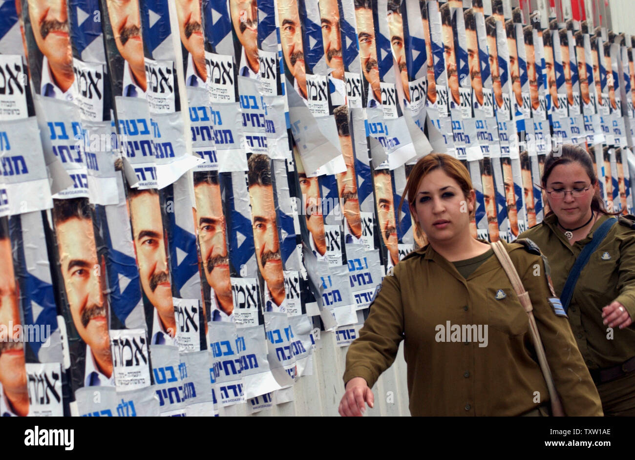 Soldati israeliani a piedi passato campain poster per il capo del partito laburista Amir Peretz, in Tel Aviv il 26 marzo 2006. Gli israeliani faranno capo alle urne per le elezioni generali di Martedì, Marzo 28. (UPI foto/Debbie Hill) Foto Stock