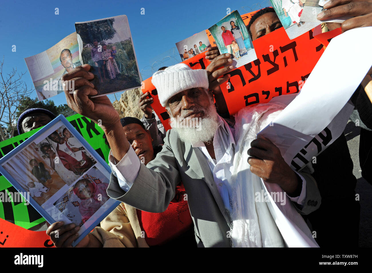Etiope israeliani tenere le foto di parenti ancora in Etiopia a una dimostrazione al di fuori del Primo Ministro israeliano Benjamin Netanyahu dell'ufficio in Gerusalemme, 10 gennaio 2009. I manifestanti hanno chiesto al governo di fine della politica di discriminazione contro la concessione di immigrazione di ebrei etiopi. Ci sono alcuni 8.700 ebrei etiopi ancora in attesa di immigrare in Israele . UPI/Debbie Hill Foto Stock