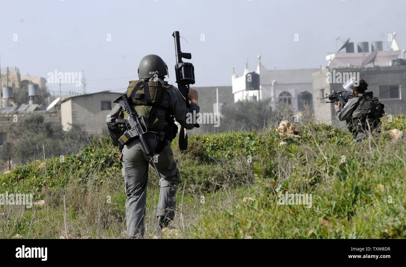 Frontiera israeliana di polizia inseguire i dimostranti palestinesi, non visto, nella West Bank village En Nabi Salih, 12 febbraio 2010. Palestinesi dire il vicino insediamento israeliano Halamish sta prendendo la loro terra e acqua. UPI/Debbie Hill Foto Stock