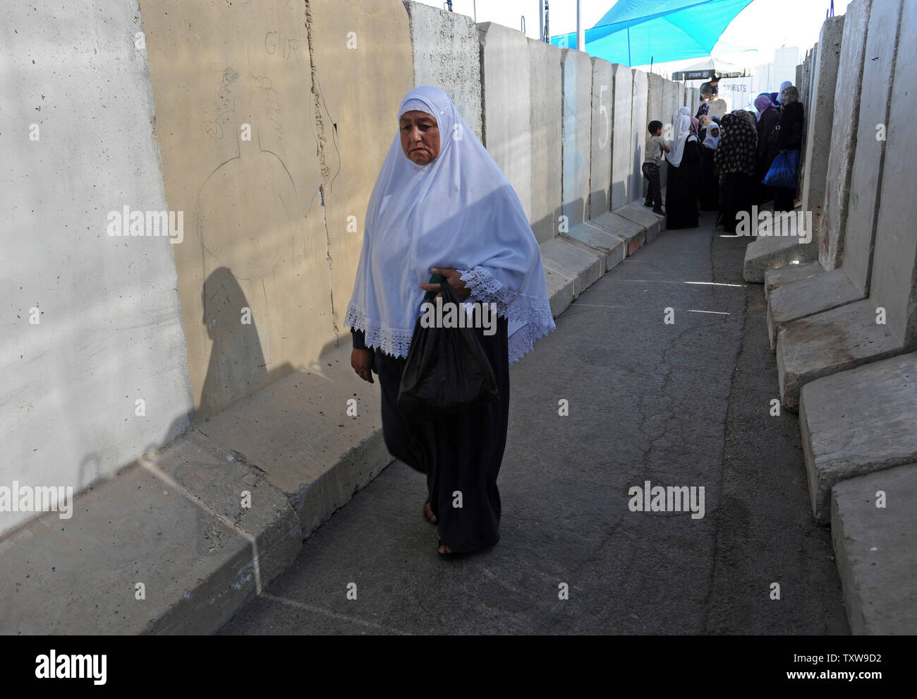 Una donna Palestinese passeggiate da barriere di cemento dopo essere stato negato il passaggio attraverso la controllata israeliana Betlemme checkpoint israeliano dalla polizia di frontiera il secondo venerdì di il mese del Ramadan, 20 agosto 2010. UPI/Debbie Hill Foto Stock