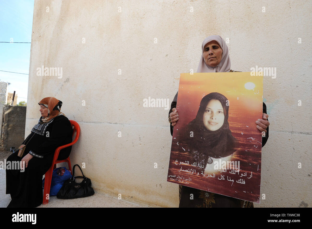 Eftikhar Tamimi detiene una foto di sua sorella,terroristici di Hamas, Ahlam Tamimi, nella sua casa di Nabi Saleh in Cisgiordania, Ottobre 17, 2011. Ahlam Tamimi fu condannato a 16 frasi di vita per il suo ruolo nel 2001 attentato suicida a Gerusalemme ristorante pizzeria che ha ucciso 15 israeliani. Tamimi è dovuto ad essere rilasciato in un prigioniero di swap per lo scambio per catturato il soldato israeliano Gilad Shalit. Centinaia di palestinesi a causa di essere rilasciati sono servire la vita o più frasi di vita per gli atti terroristici che hanno ucciso decine di civili israeliani. UPI/Debbie Hill Foto Stock