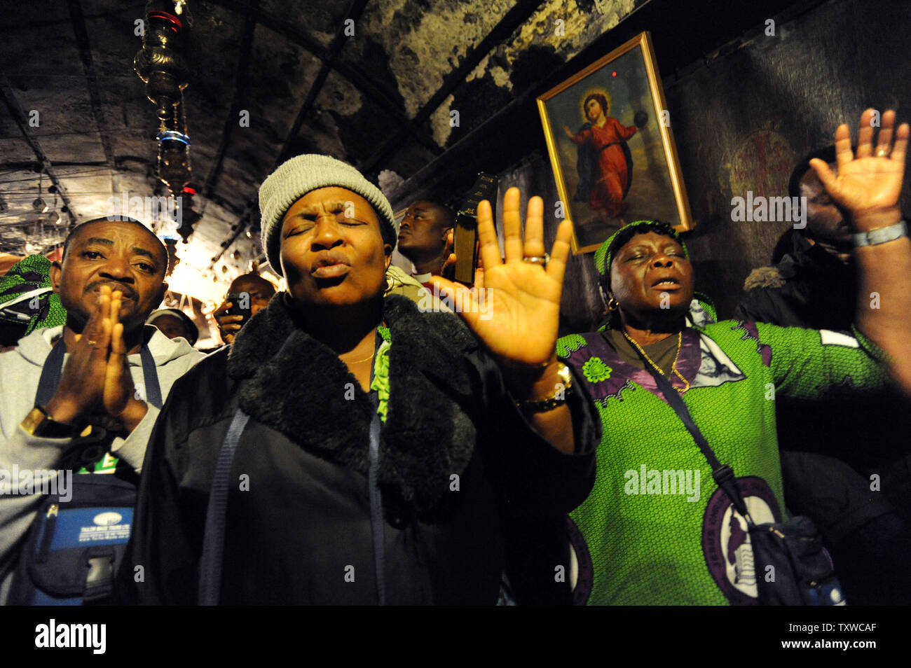 I cristiani dalla Nigeria pregare nella grotta nella chiesa della Natività, dove la tradizione crede che Gesù Cristo è nato, alla vigilia di Natale in città biblica di Betlemme, West Bank, Dicembre 24, 2011. UPI/Debbie Hill Foto Stock