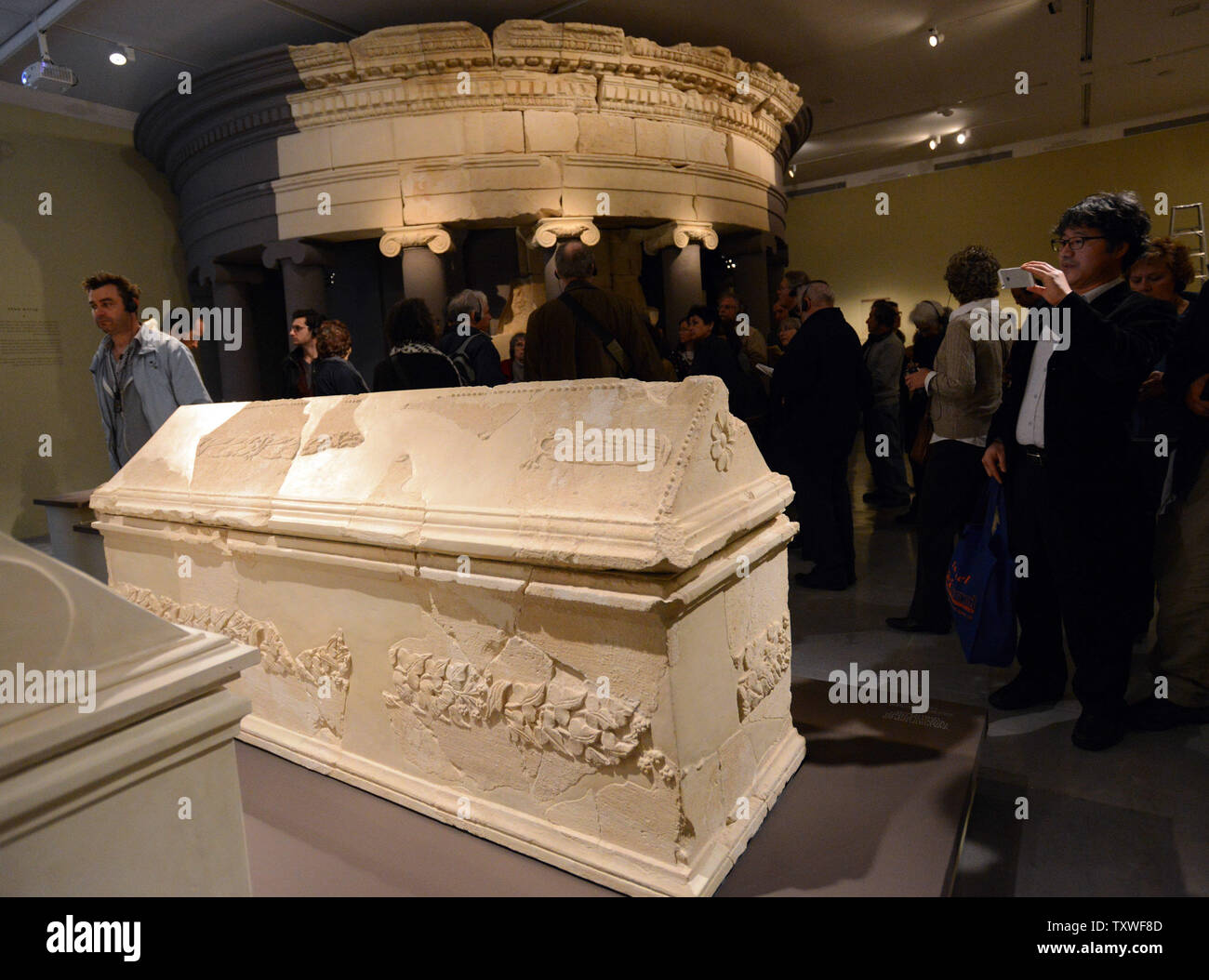 Visitatori guardare un sarcofago accanto a una ricostruzione della tomba del re Erode che era stato costruito in fortezza erodiano, a sud di Gerusalemme, esposti in una mostra intitolata "Erode il Grande: Del Re ultimo viaggio,' nel Museo di Israele, a Gerusalemme, Israele, 12 febbraio 2013. La mostra si occupa di 40 anni di scavi archeologici della vita e l'eredità del re Erode che è ricordato come il più grande costruttore nella storia umana. Egli è conosciuto per elaborare i palazzi, fortezze, come Masada, e la ricostruzione del tempio di Gerusalemme in epoca romana. Erode governata per oltre trenta y Foto Stock