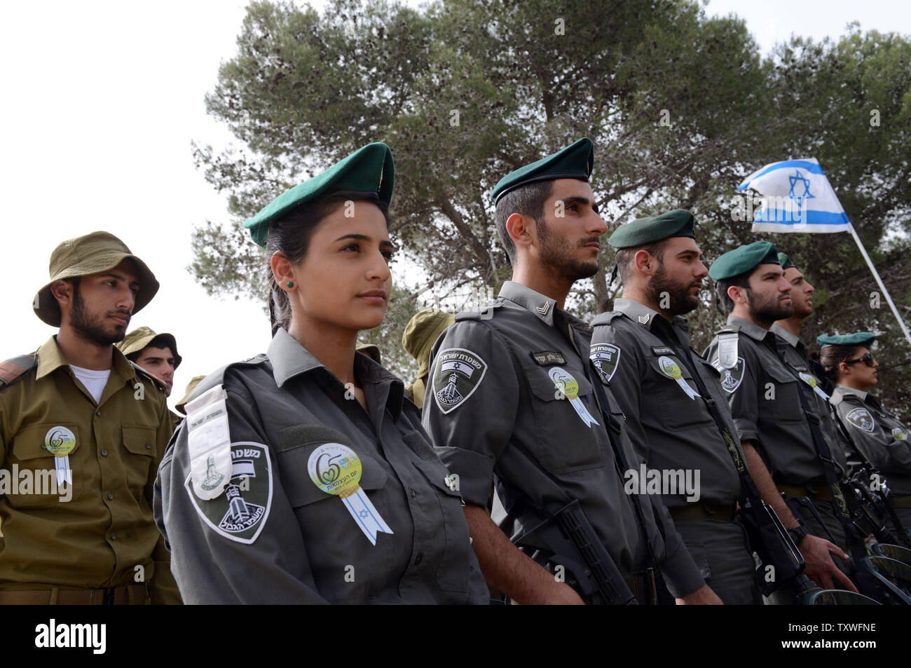 Frontiera israeliana polizia resta in silenzio come un due minuti di sirena suona per onorare i sei milioni di ebrei che perirono sotto il regime nazista durante la Seconda Guerra Mondiale, durante un olocausto evento commemorativo sull olocausto dei martiri ed eroi' giorno del ricordo, nel martire foresta 'Scorrimento di fuoco", al di fuori di Gerusalemme, Israele, Aprile 8, 2013. UPI/Debbie Hill Foto Stock